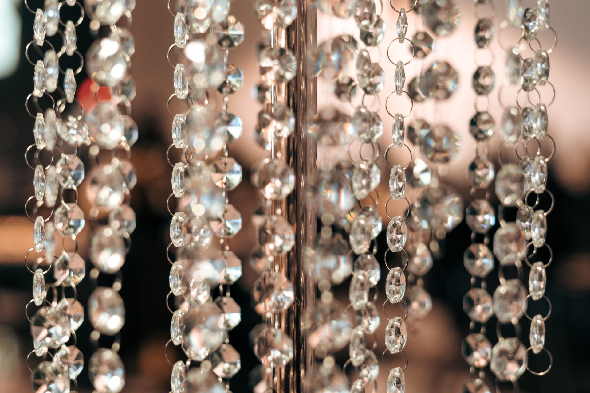 A close up of a string of crystals hanging from a chandelier.