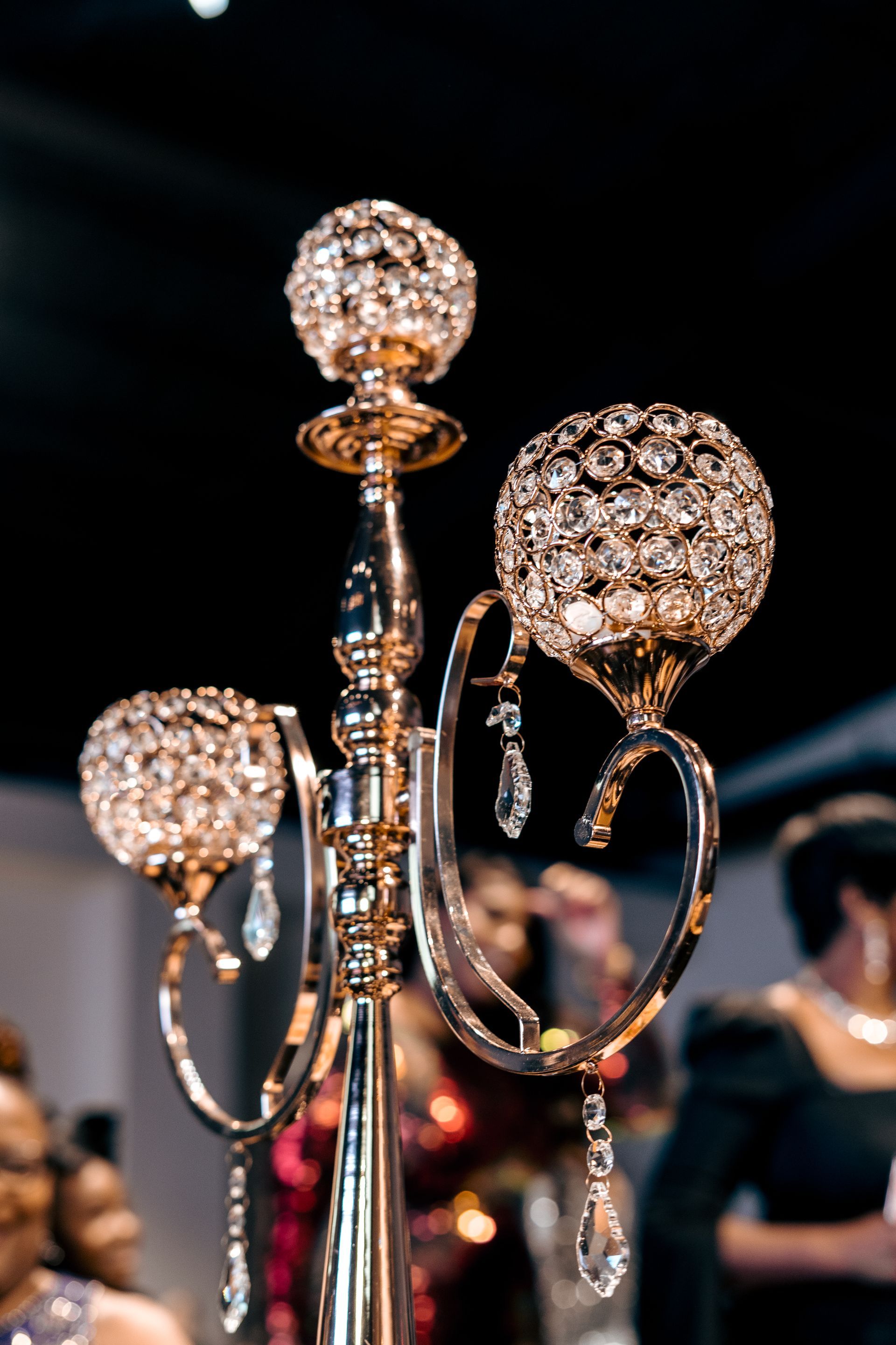 A close up of a candelabra with a group of people dancing in the background.