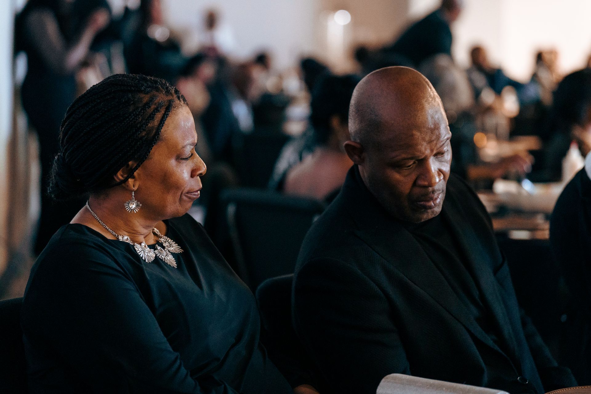 A man and a woman are sitting next to each other in a church.
