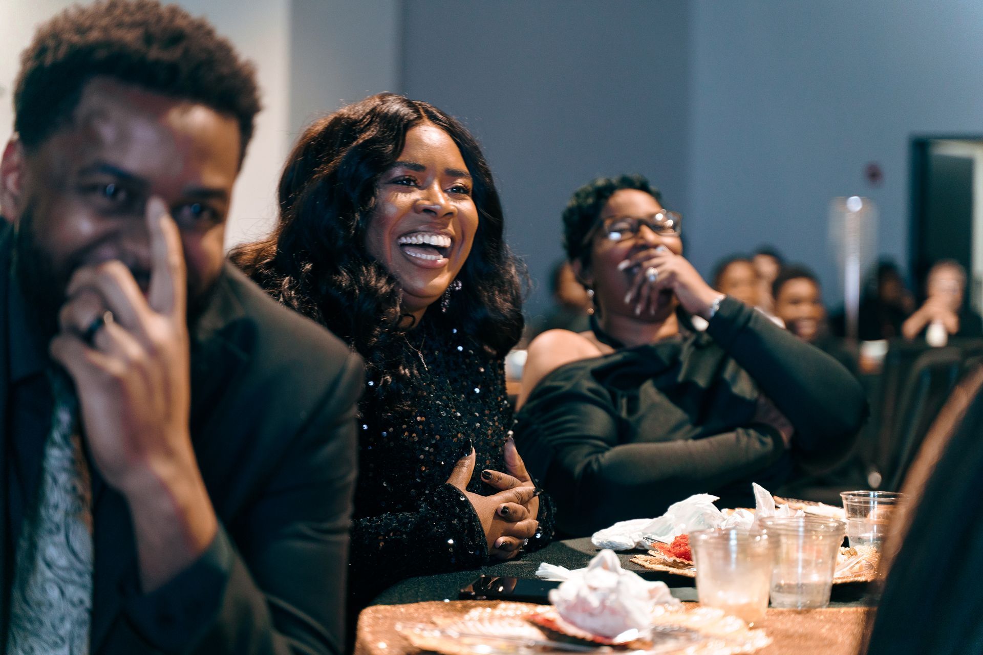 A group of people are sitting at a table laughing.