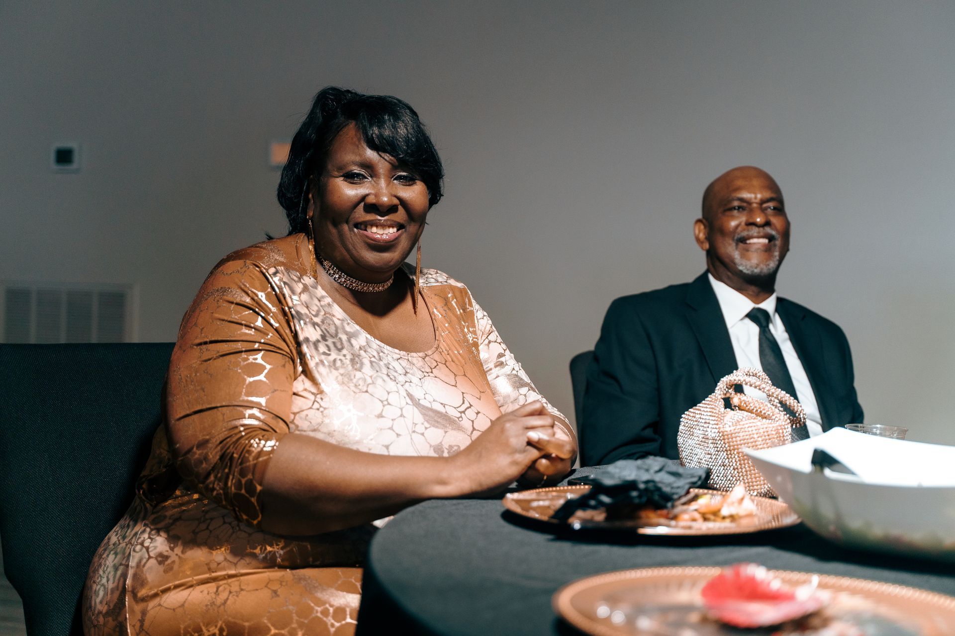 A man and a woman are sitting at a table with plates of food.