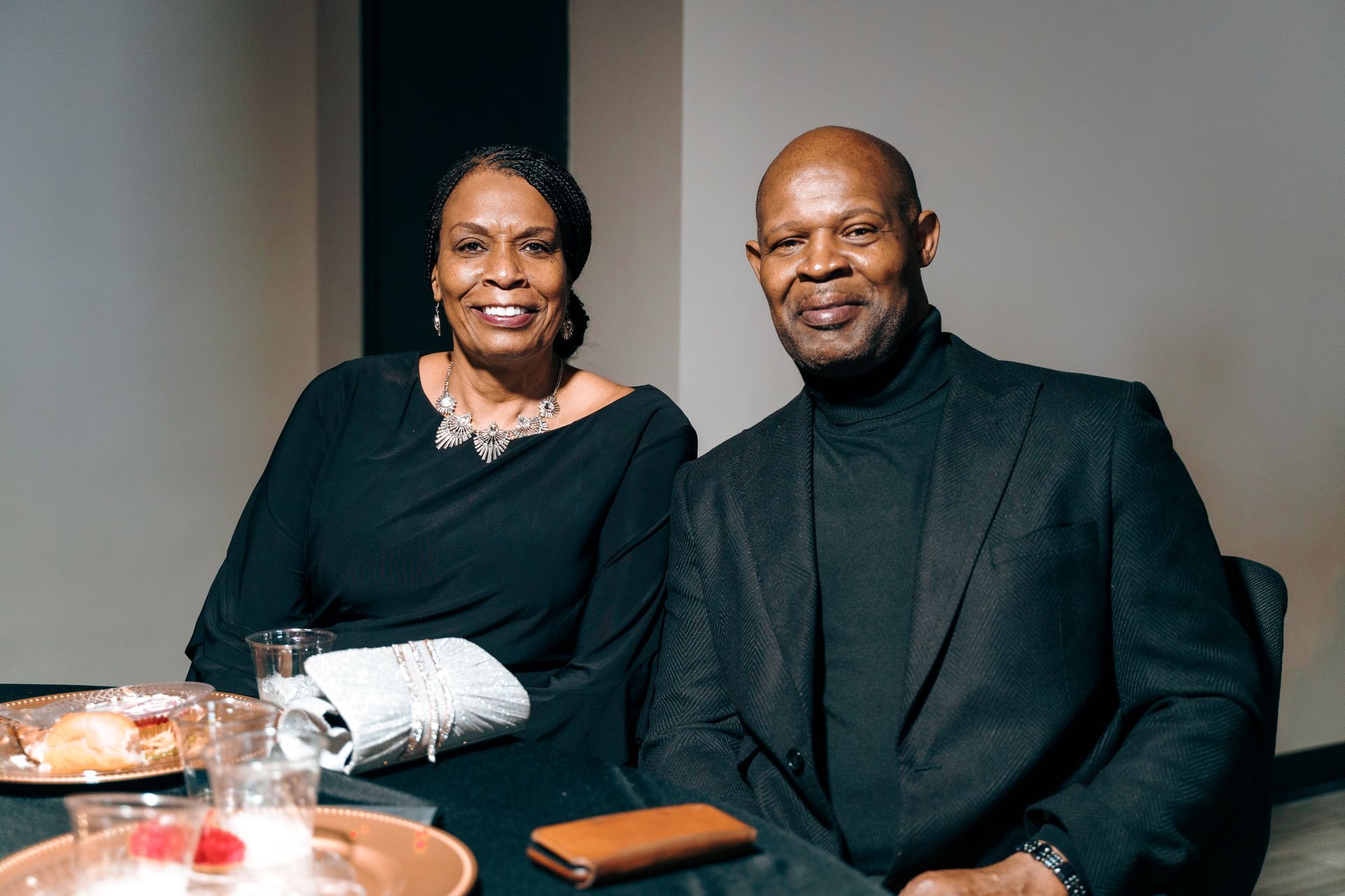 A man and a woman are sitting at a table with plates of food.