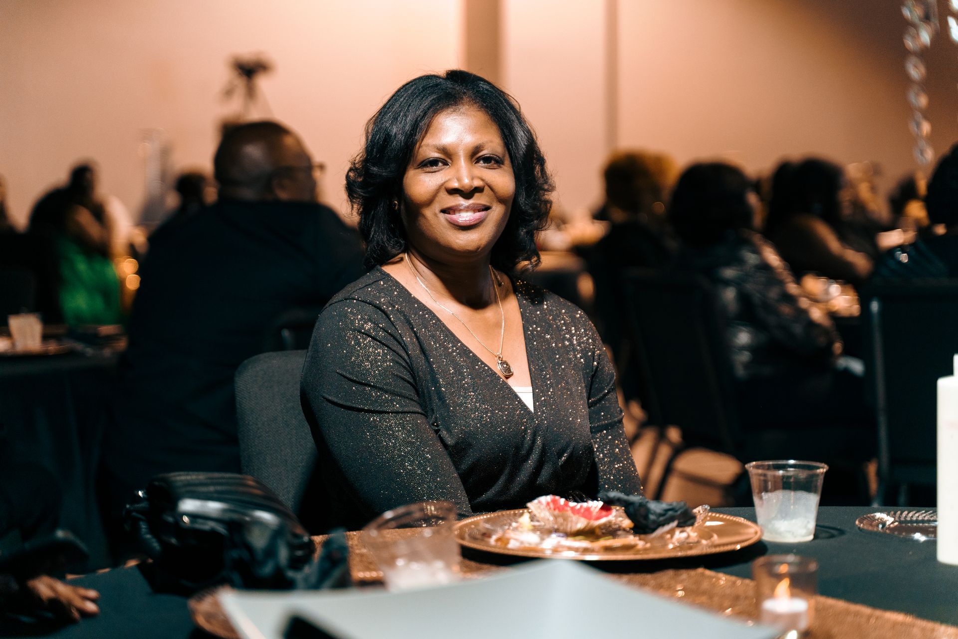 A woman is sitting at a table with a plate of food.