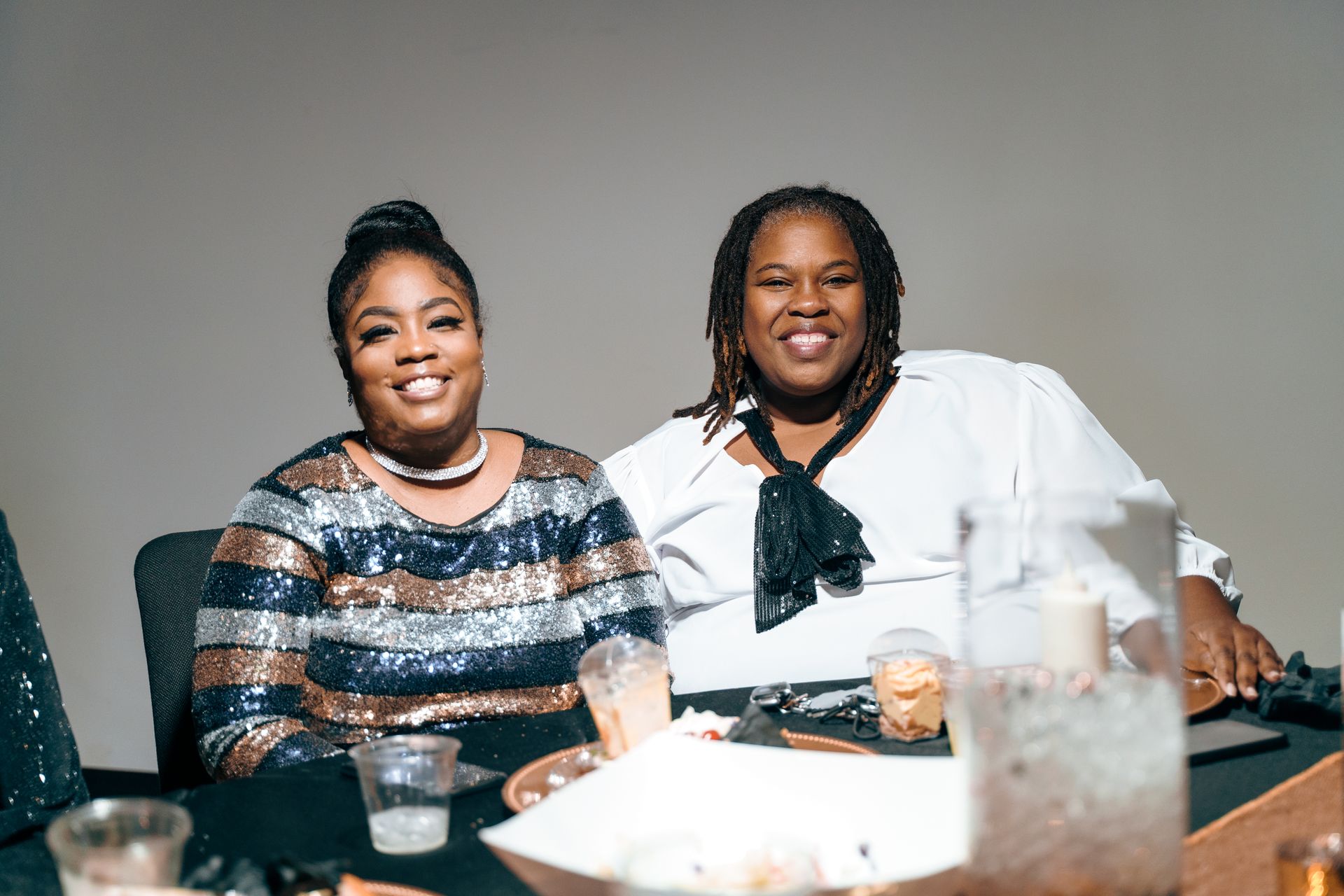 Two women are sitting at a table with drinks.