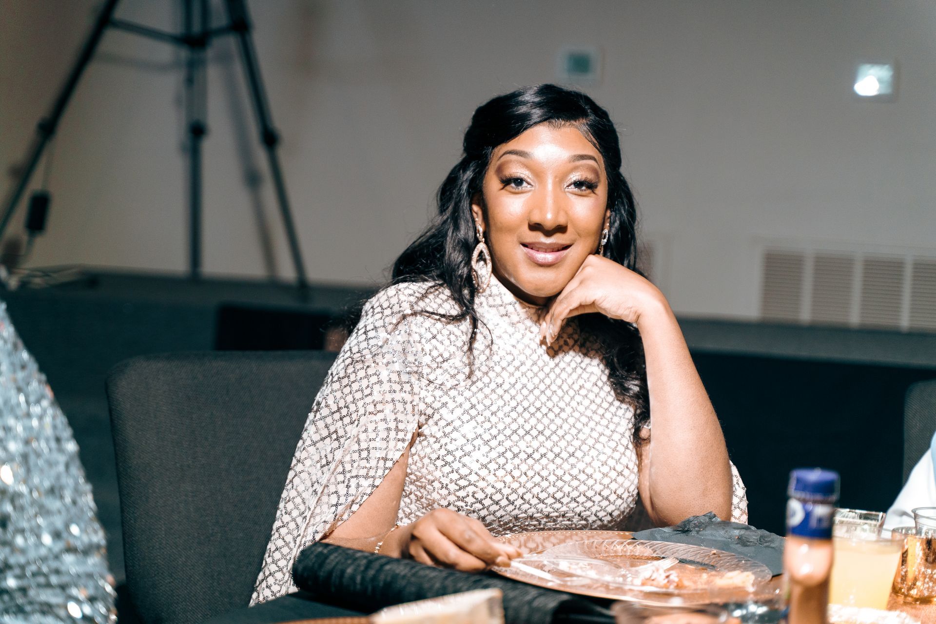 A woman is sitting at a table with her hand on her chin.