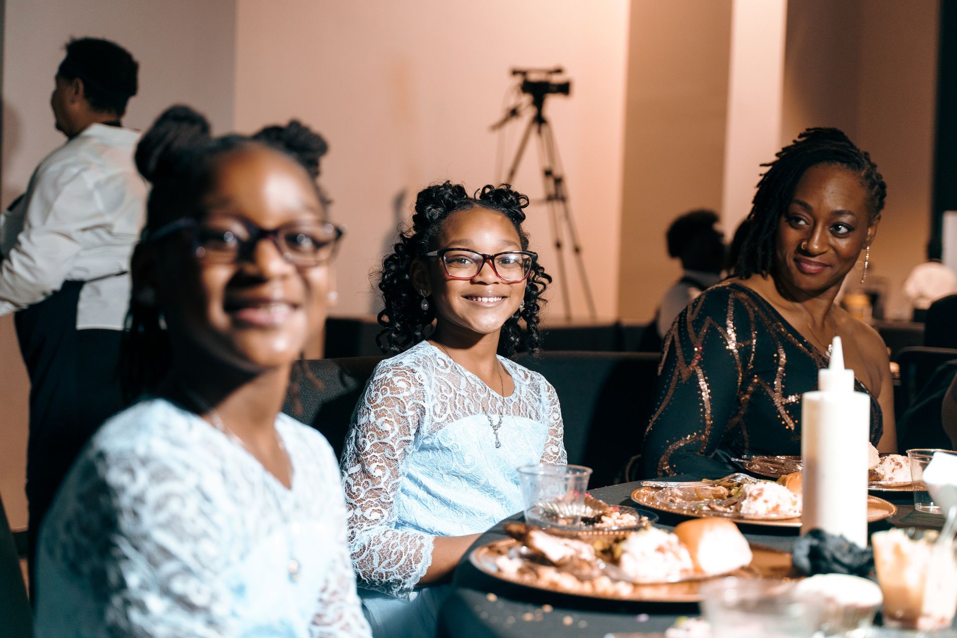A group of people are sitting at a table with plates of food.