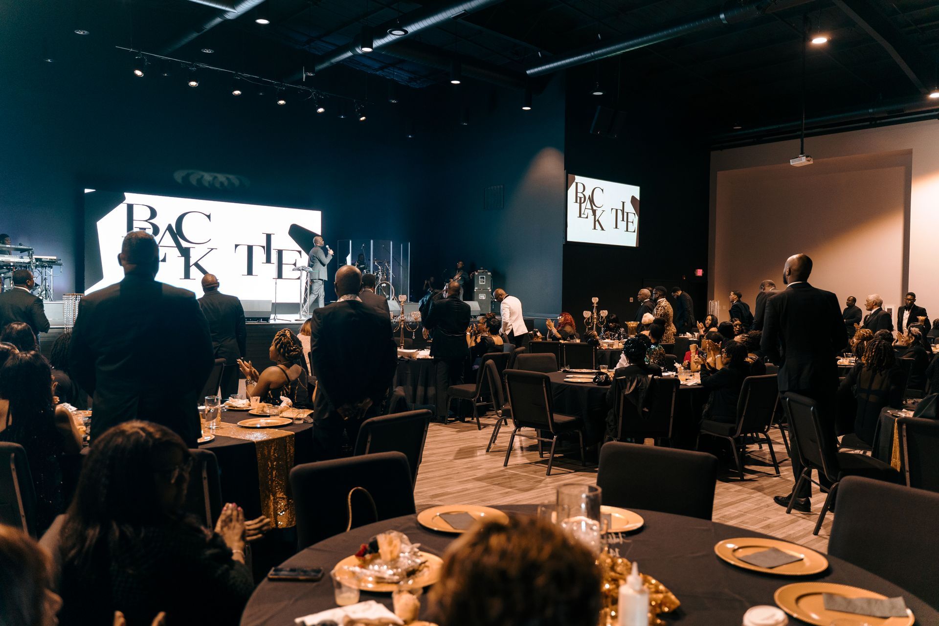 A group of people are sitting at tables in a large room.