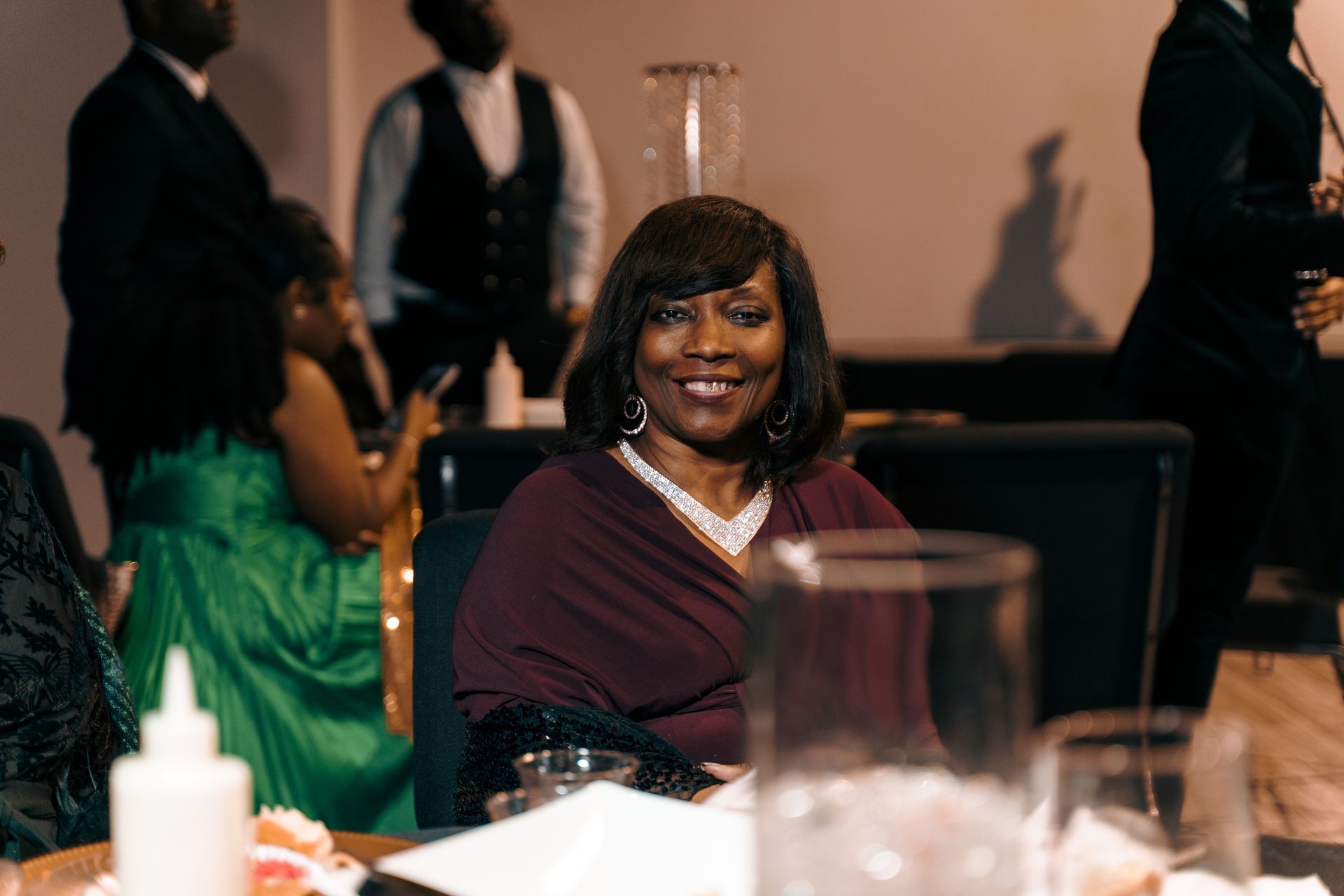 A woman is sitting at a table with a glass of water.
