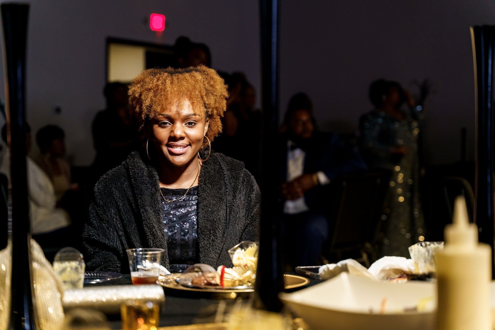 A woman is sitting at a table with a plate of food.
