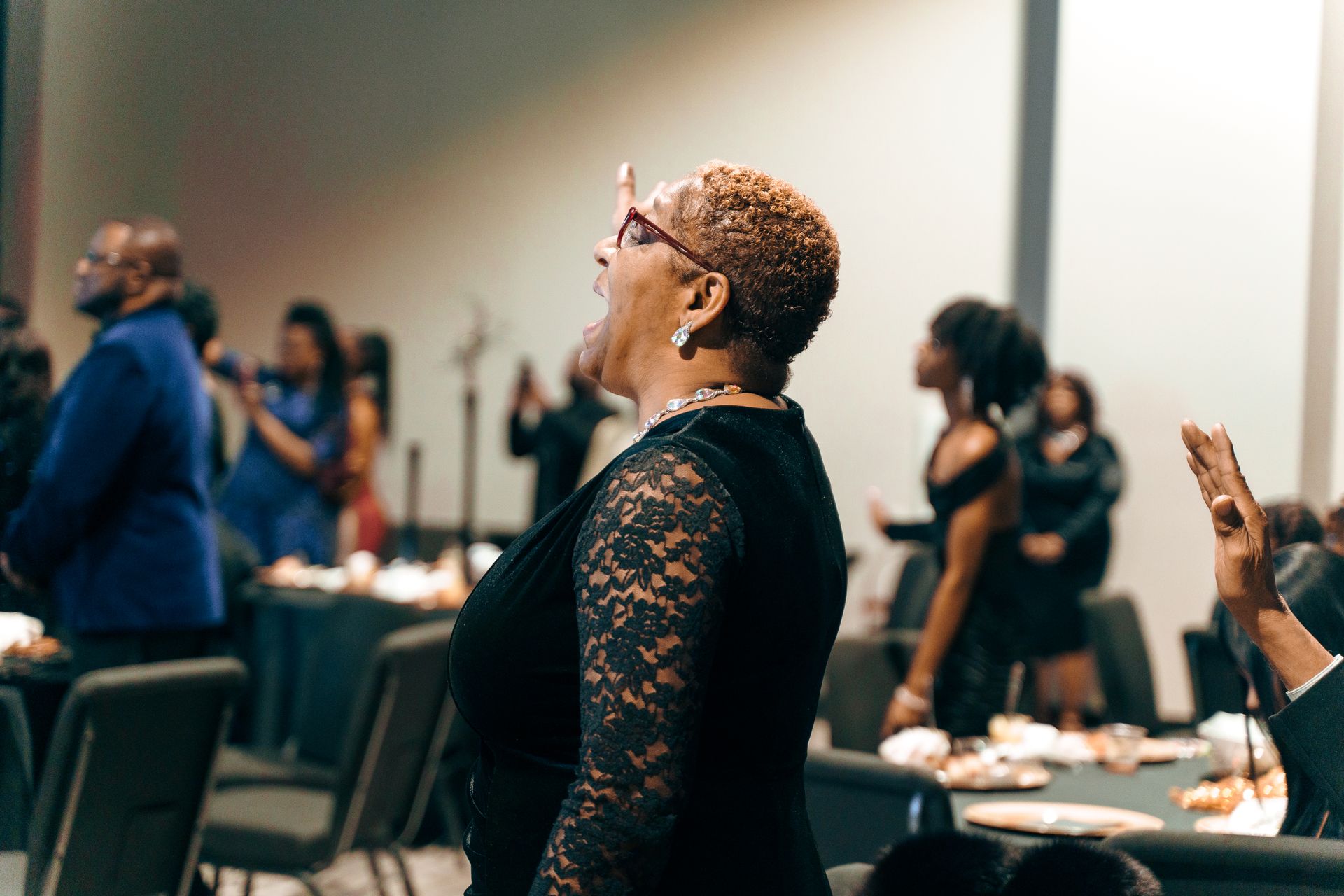 A woman is standing in front of a crowd of people at a party.