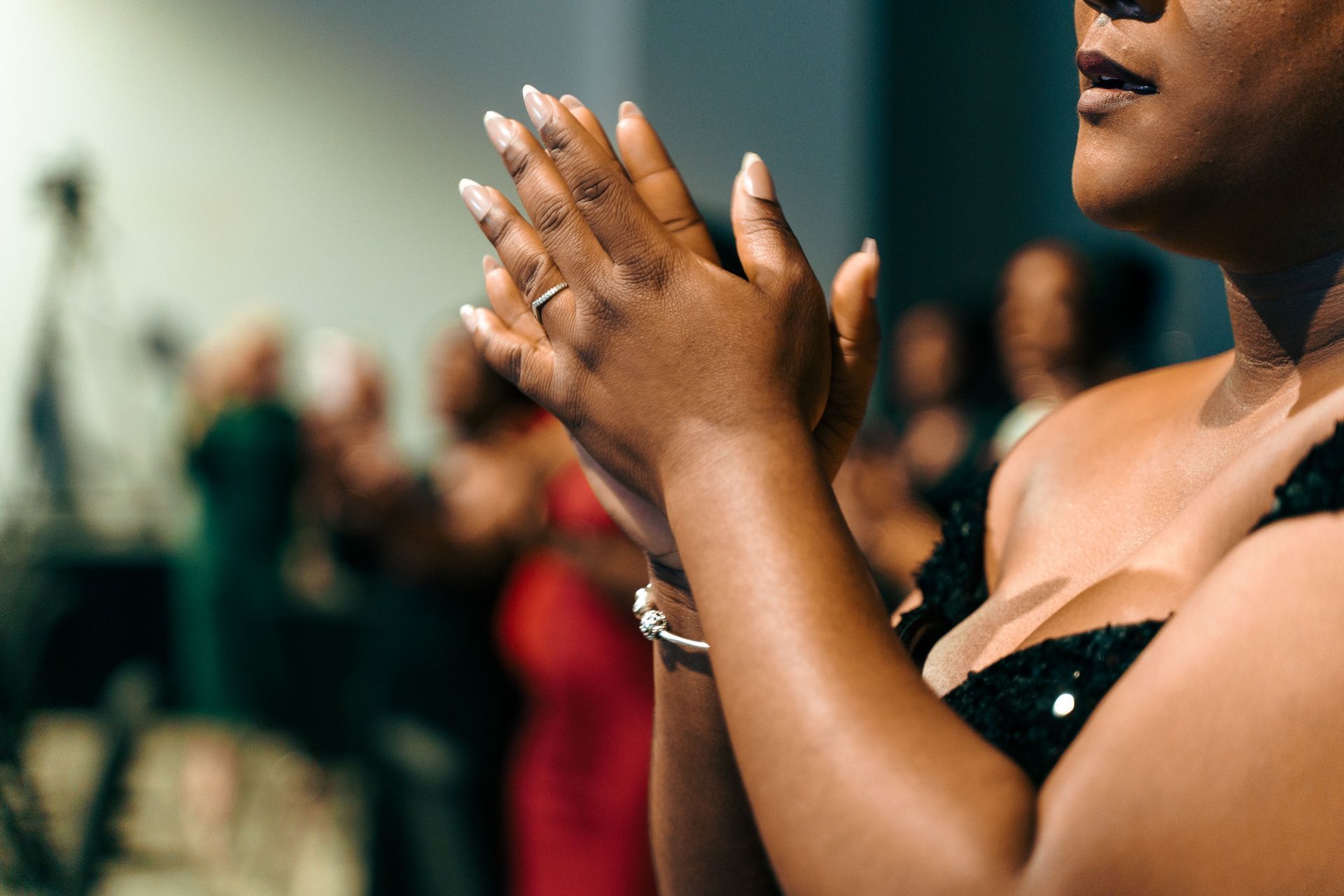 A woman is clapping her hands in a crowd of people.