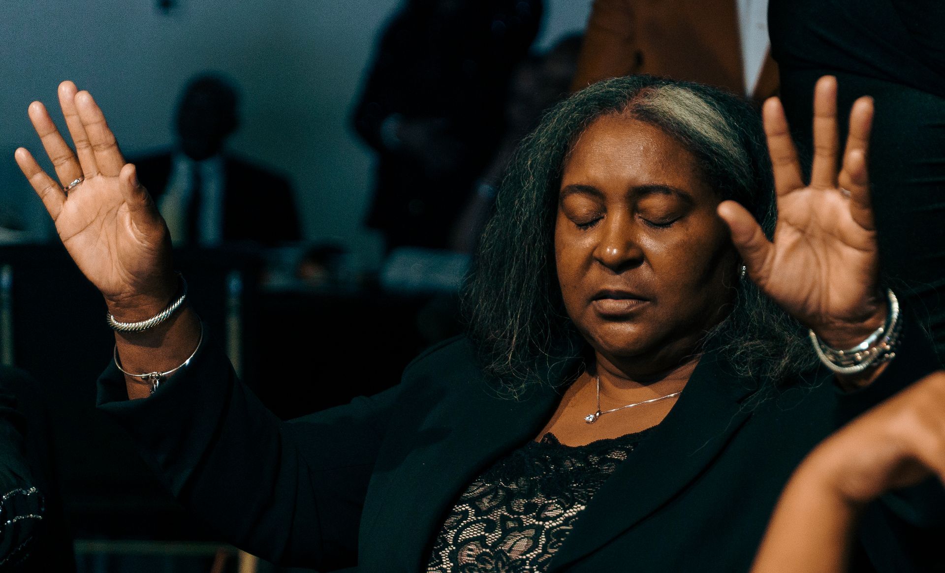 A woman is sitting in a chair with her hands in the air.