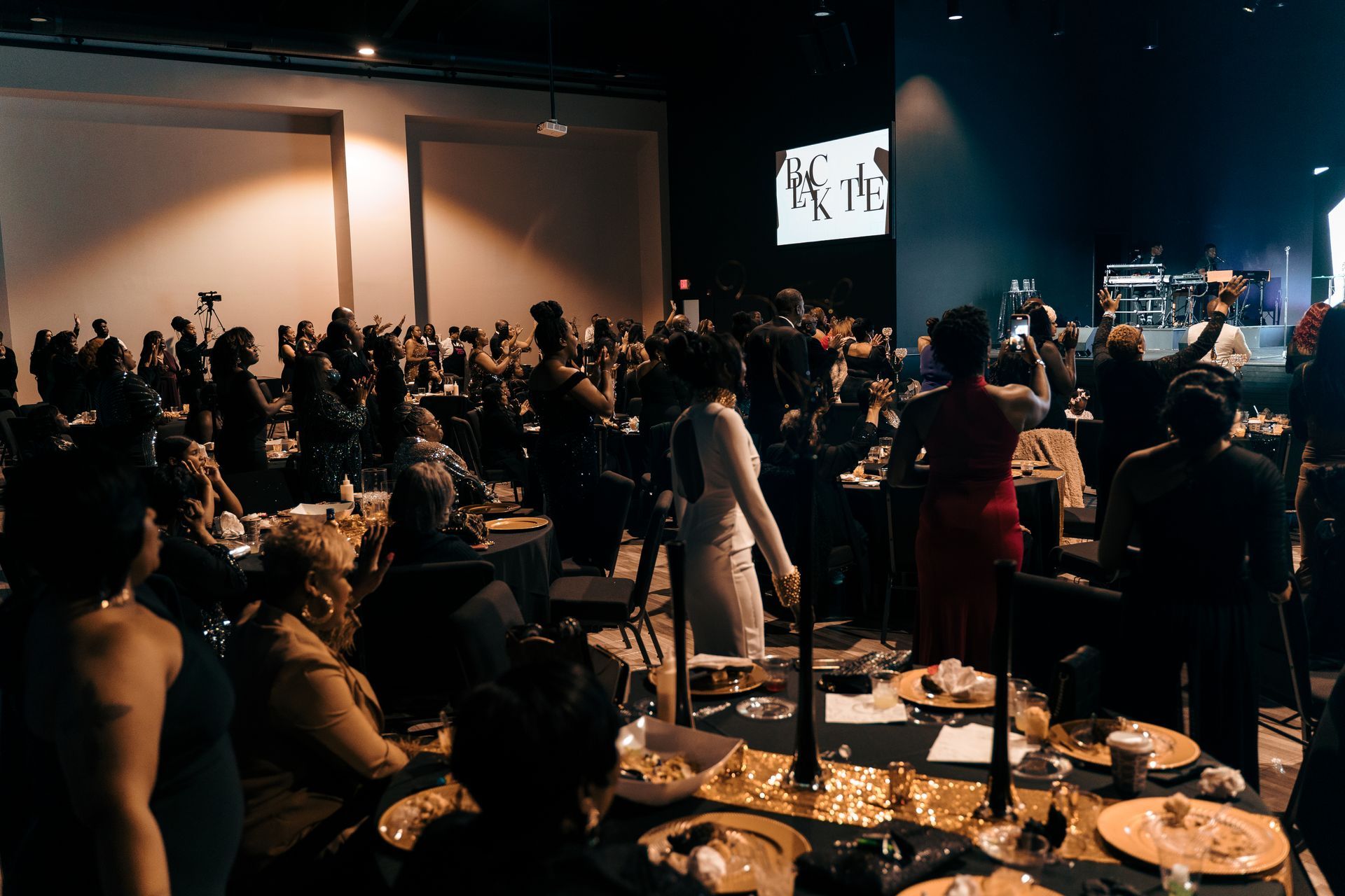 A large group of people are sitting at tables in a large room.