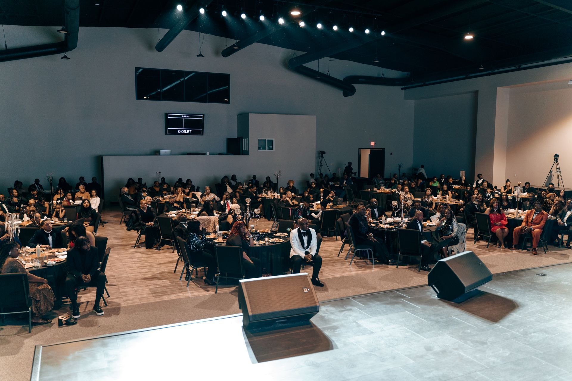 A man is standing on a stage in front of a large crowd of people.