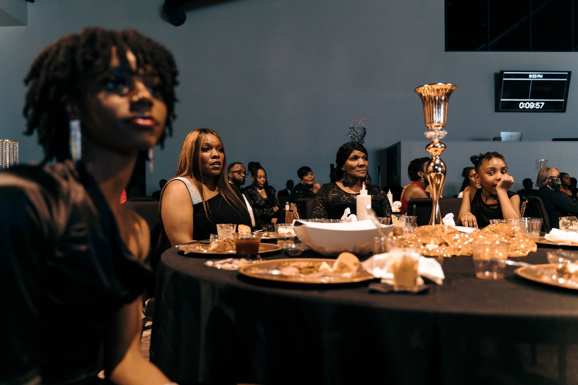 A group of women are sitting at a table at a party.
