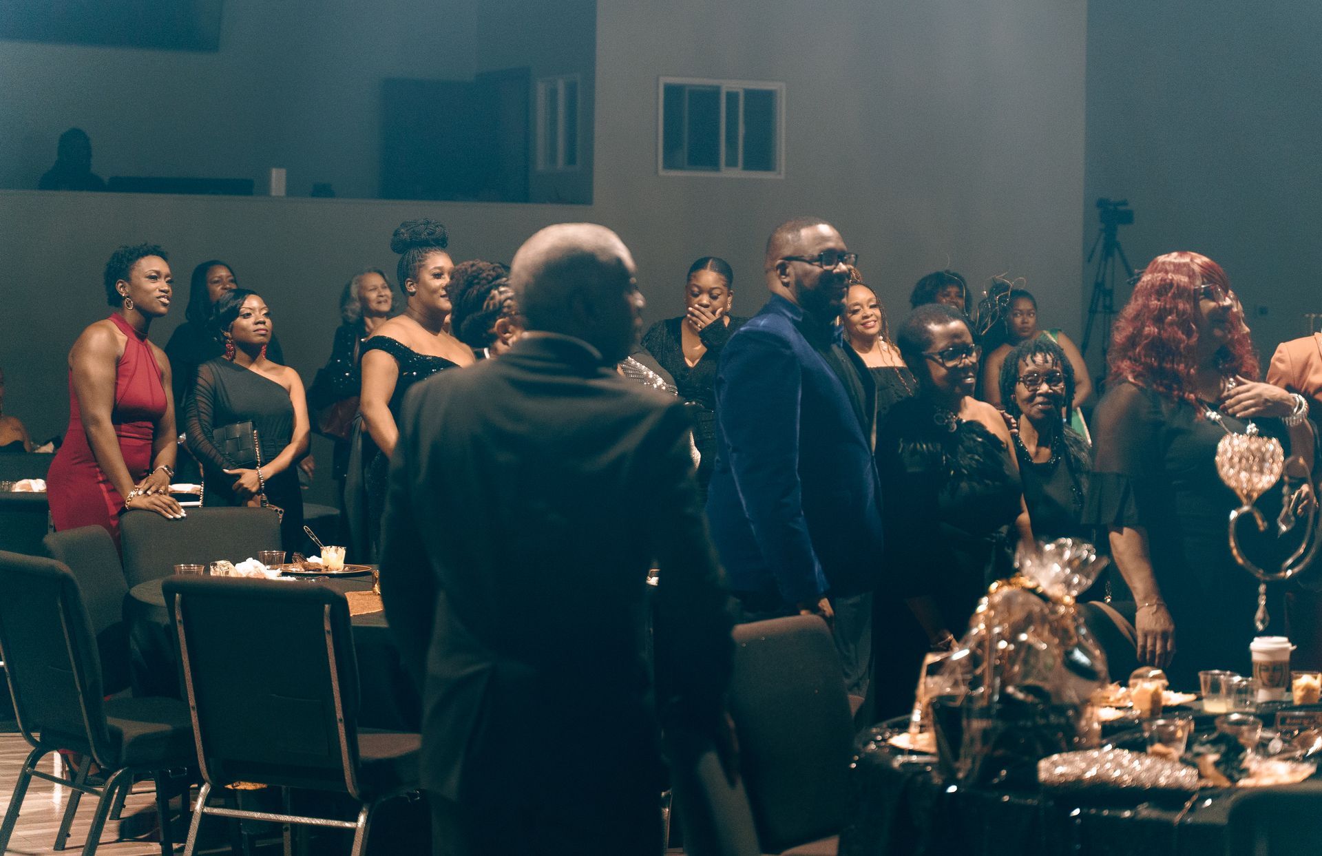 A group of people are standing around a table in a dark room.
