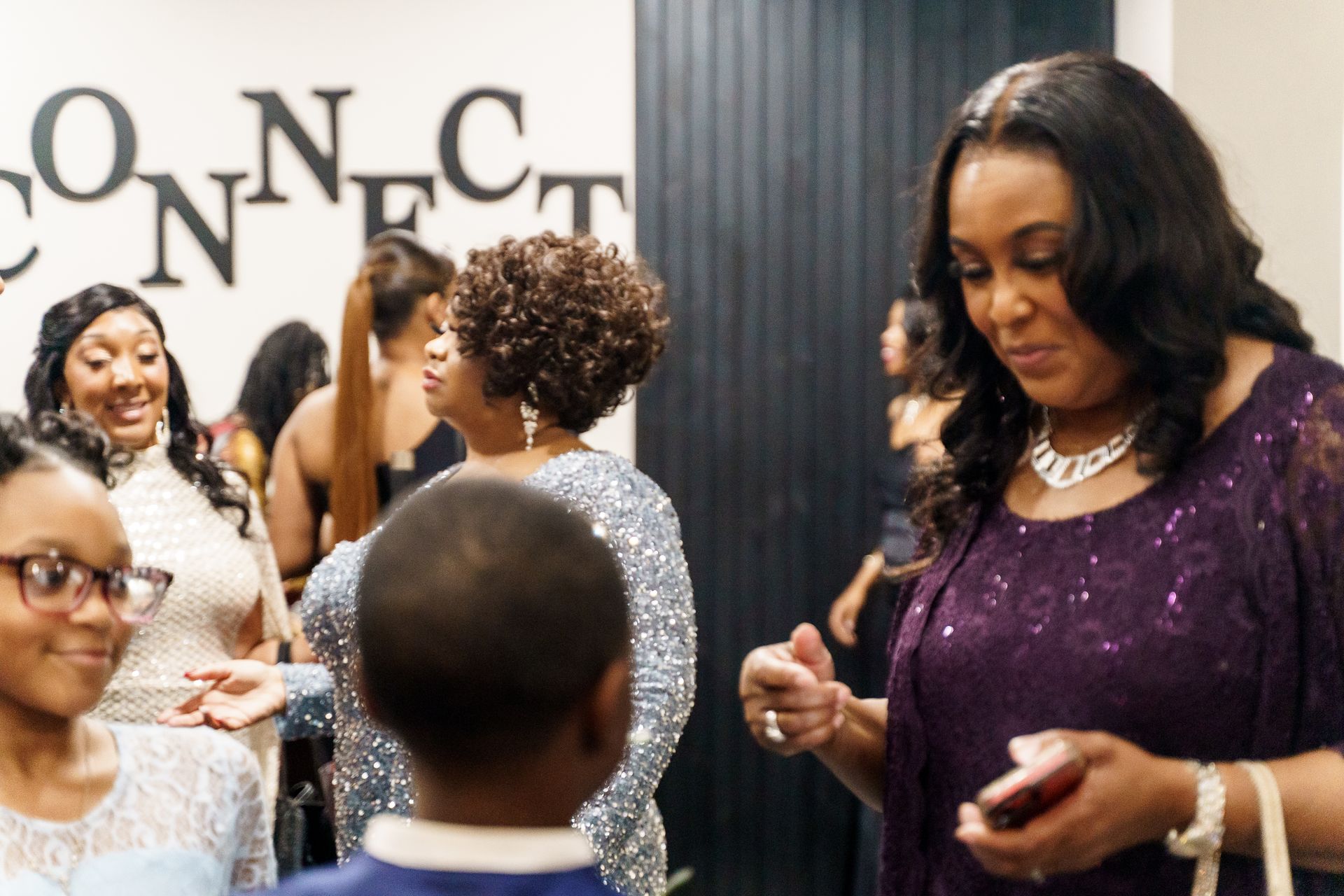 A group of people are standing in front of a sign that says connect