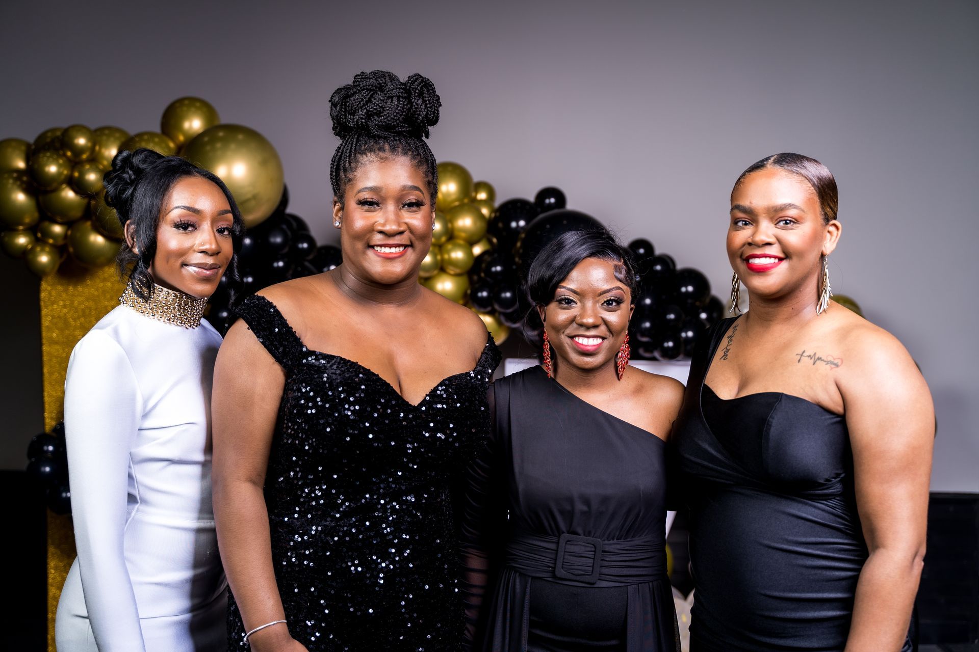 A group of women in black dresses are posing for a picture.