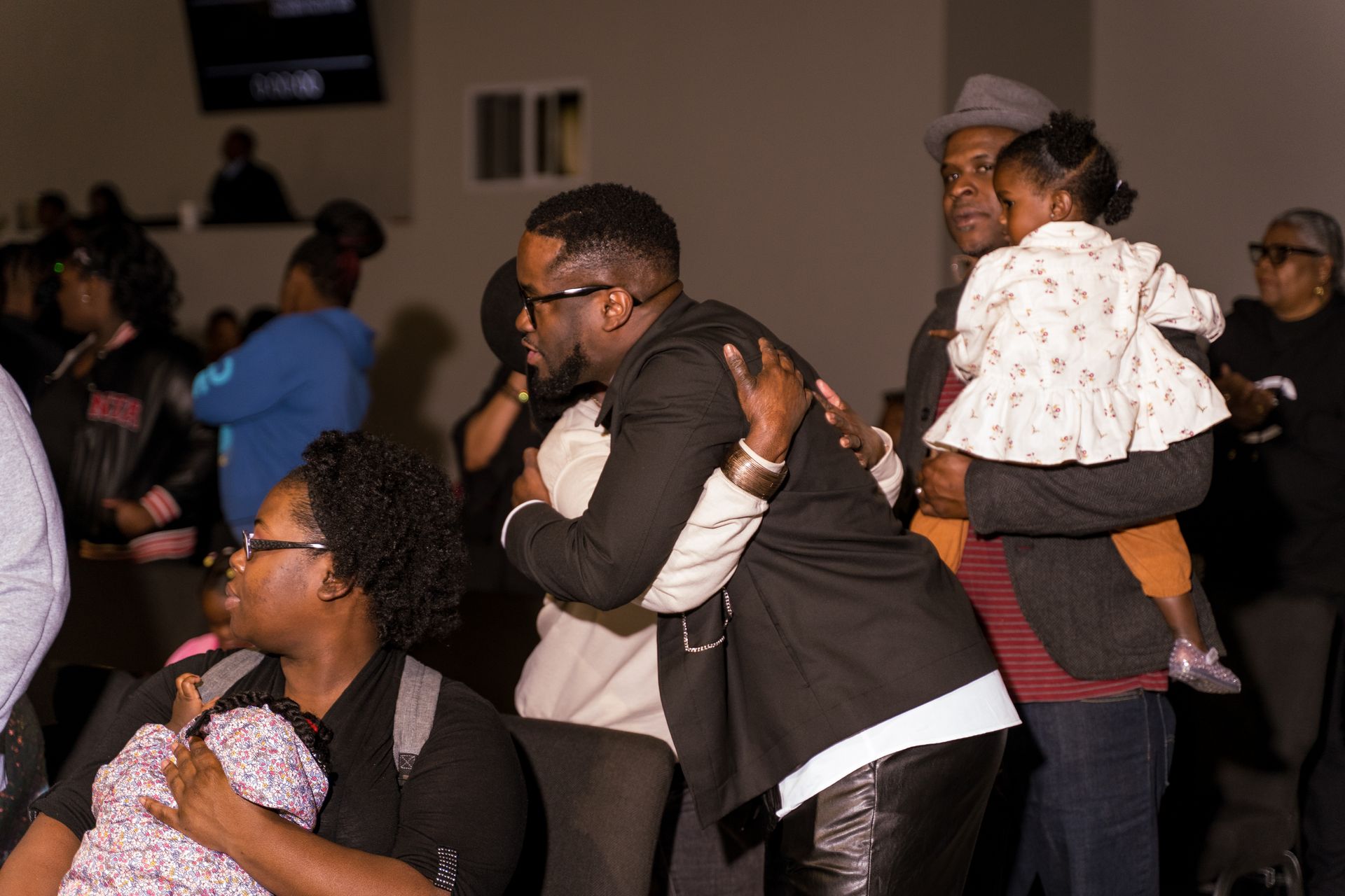 A group of people are hugging each other in a room.