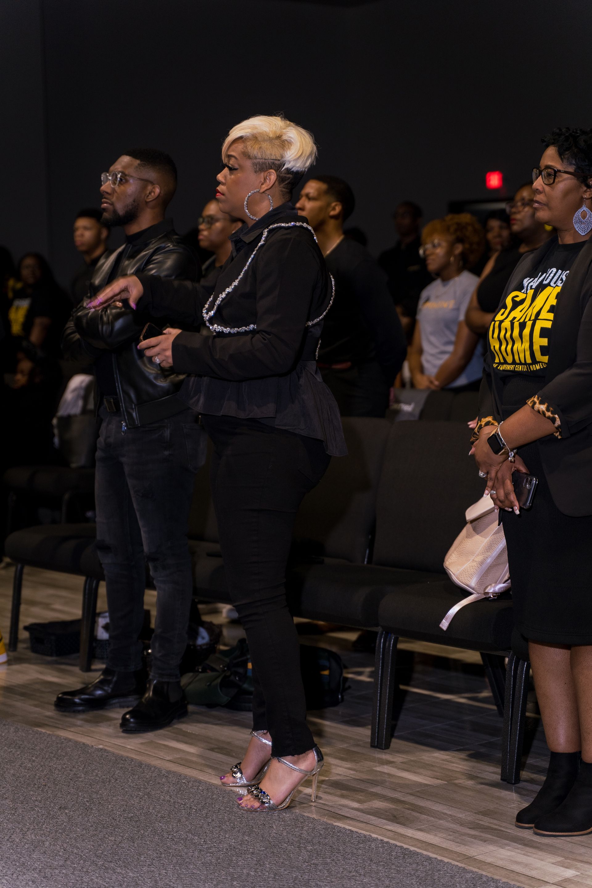 A woman is standing in front of a crowd of people in a church.