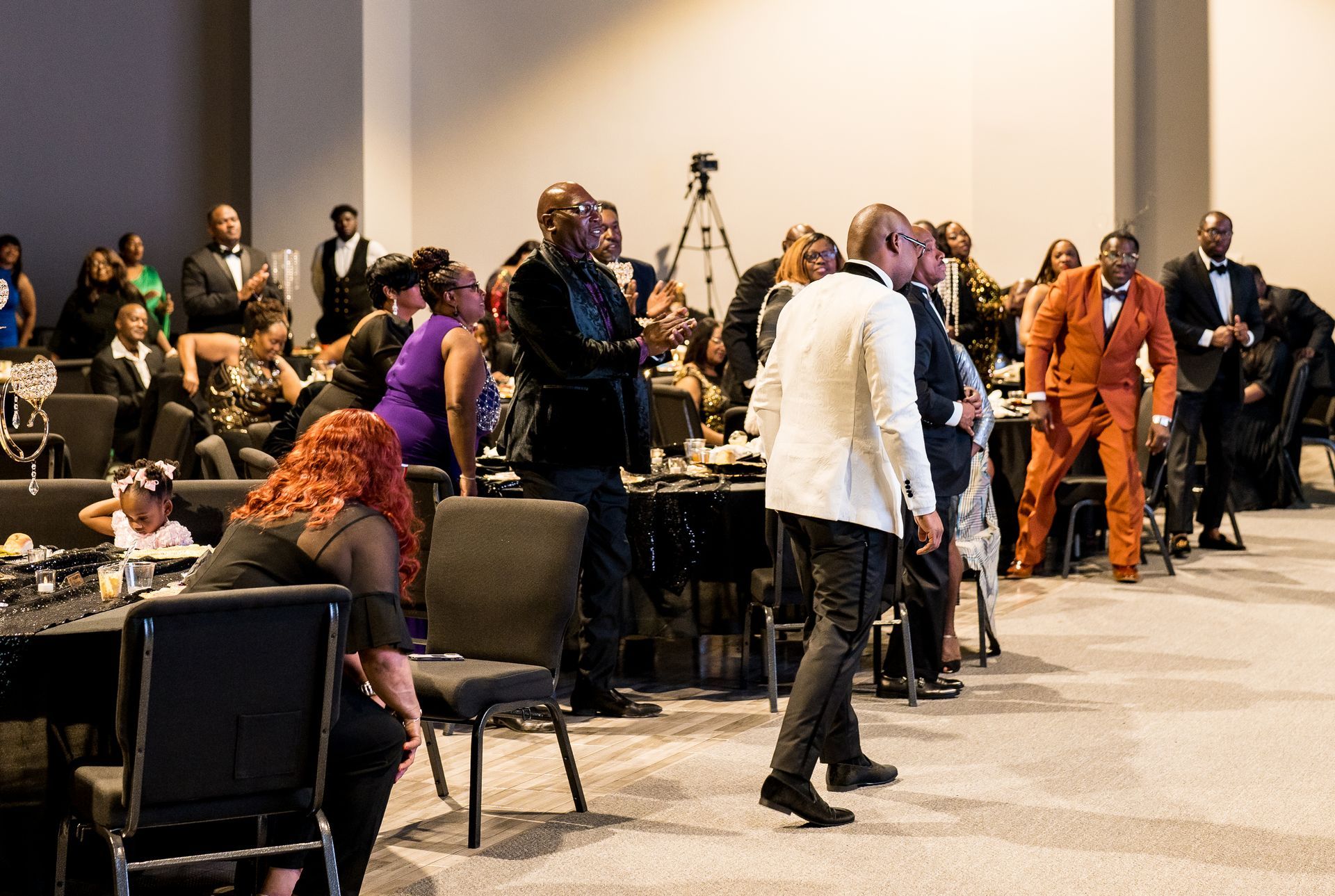 A group of people are standing in a large room.