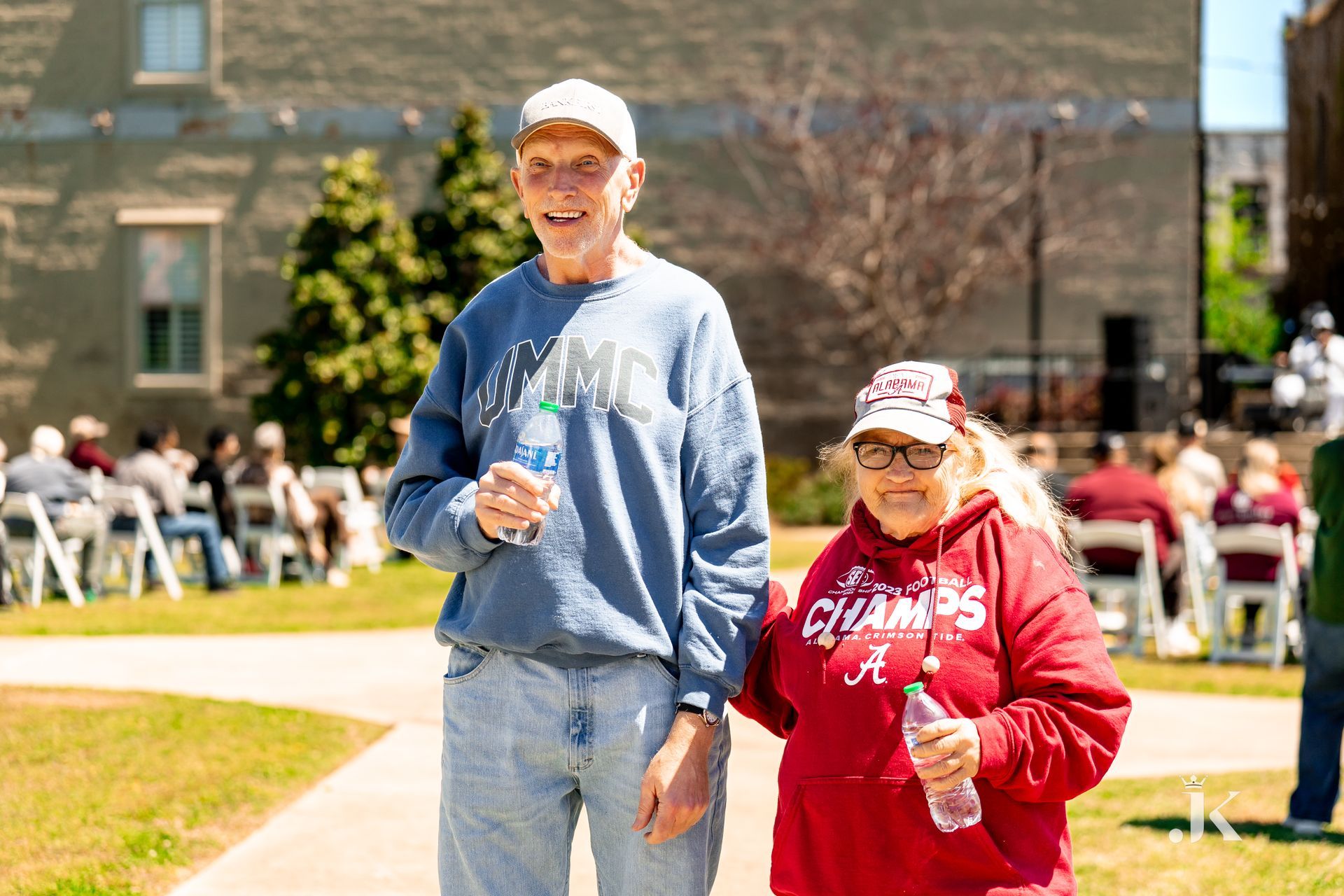A man and a woman are walking down a sidewalk holding hands.