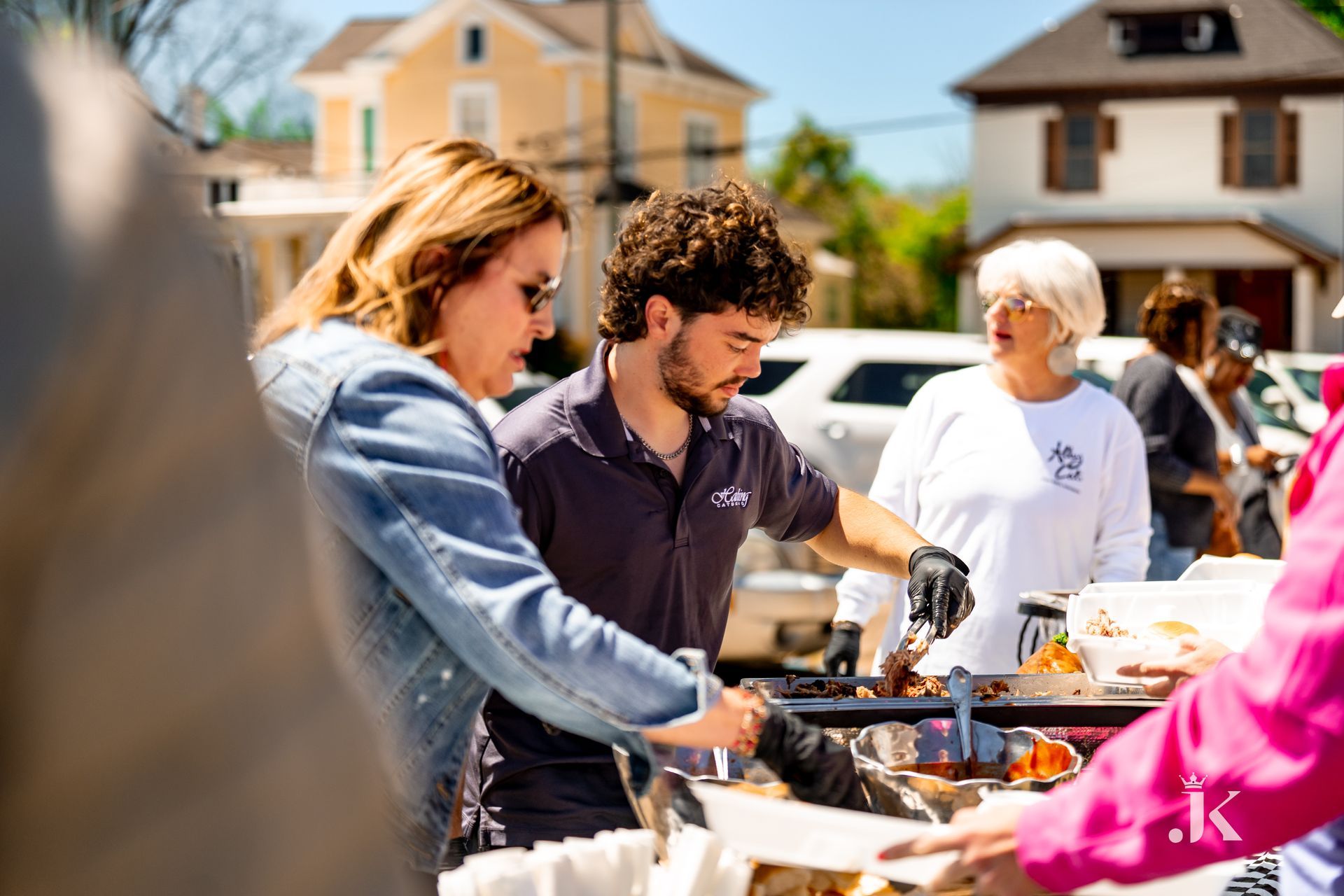 A group of people are standing around a table serving food.