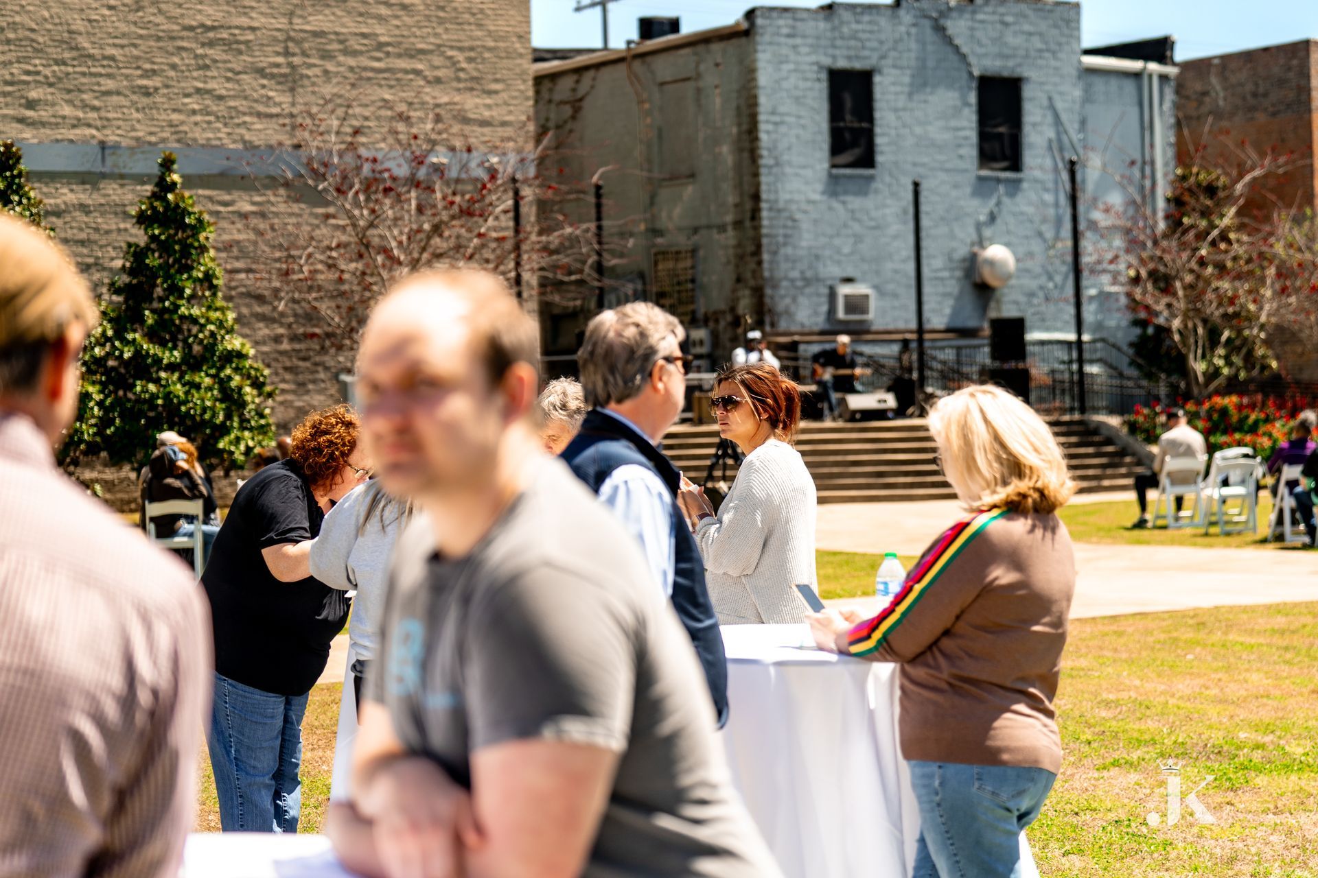 A group of people are standing around a table in a park.