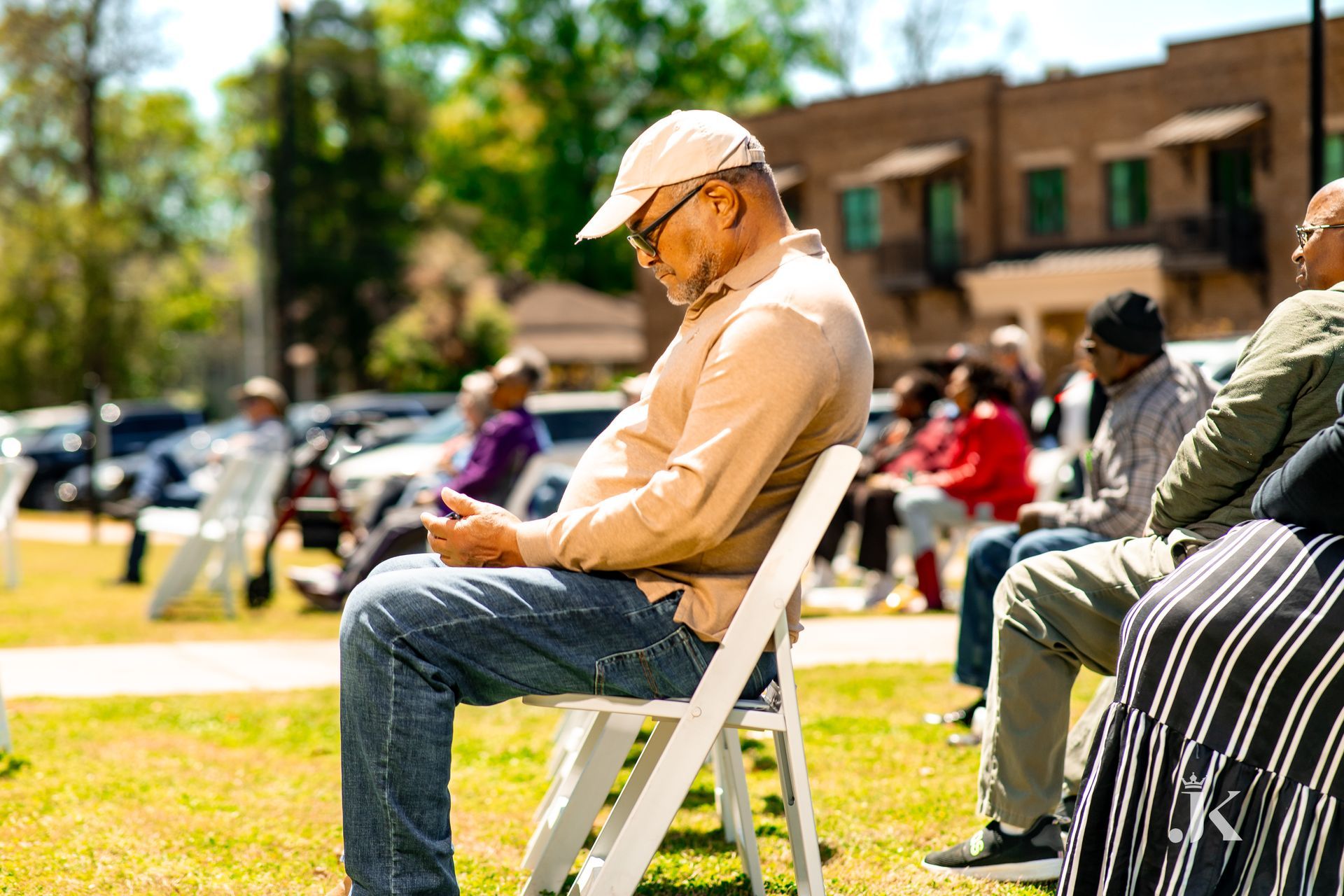 A man is sitting in a chair looking at his cell phone.