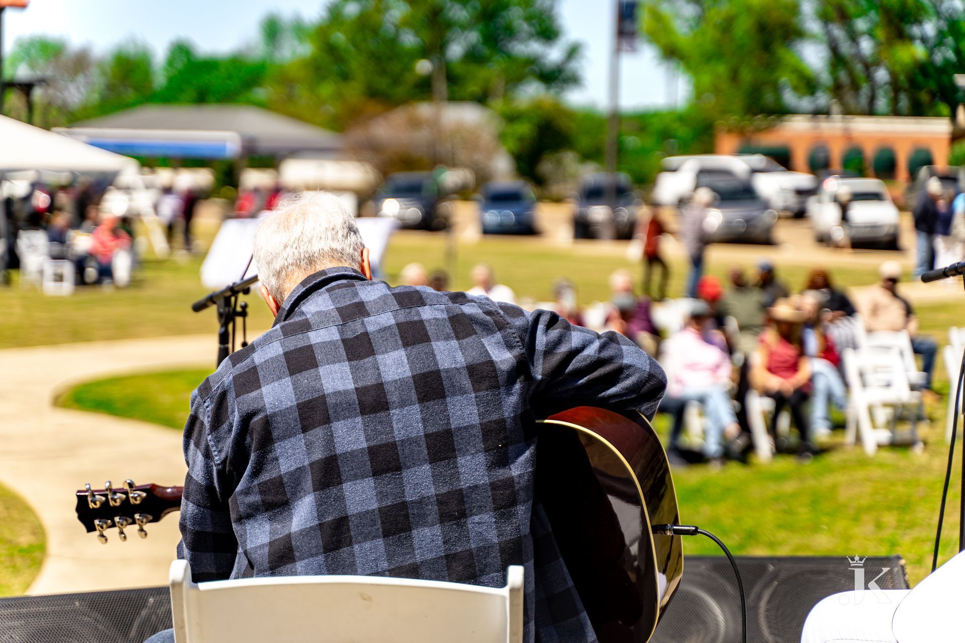 A man is playing a guitar on a stage in front of a crowd.