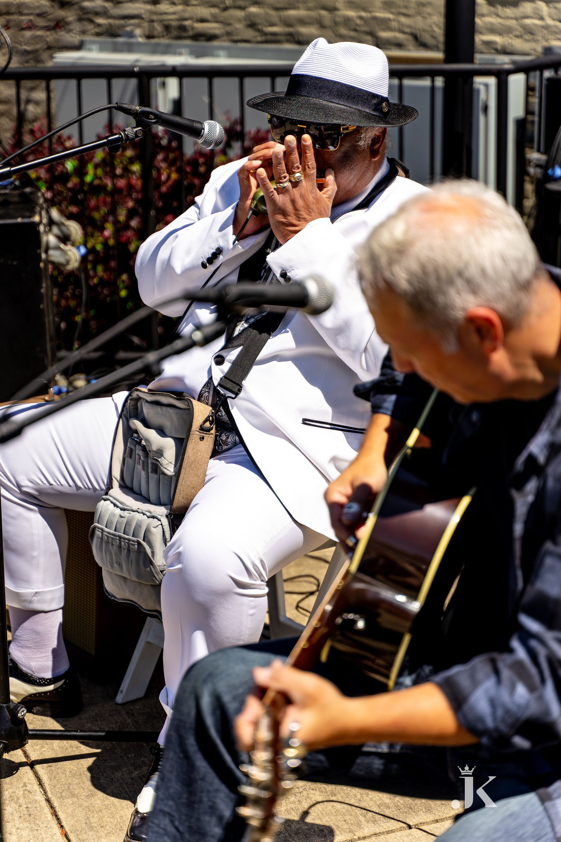 A man is playing a flute and another man is playing a guitar.