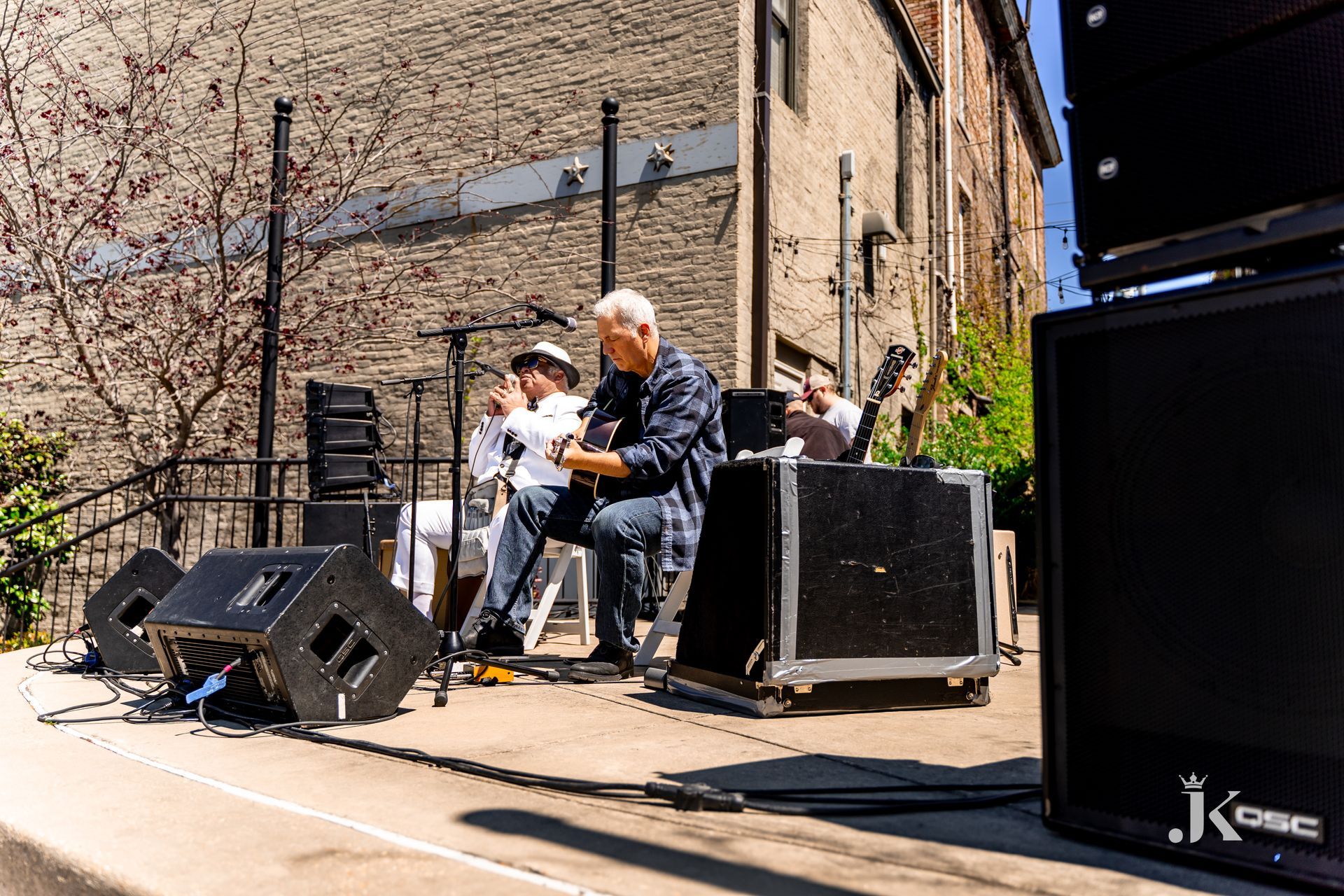 A man is playing an acoustic guitar on a stage.