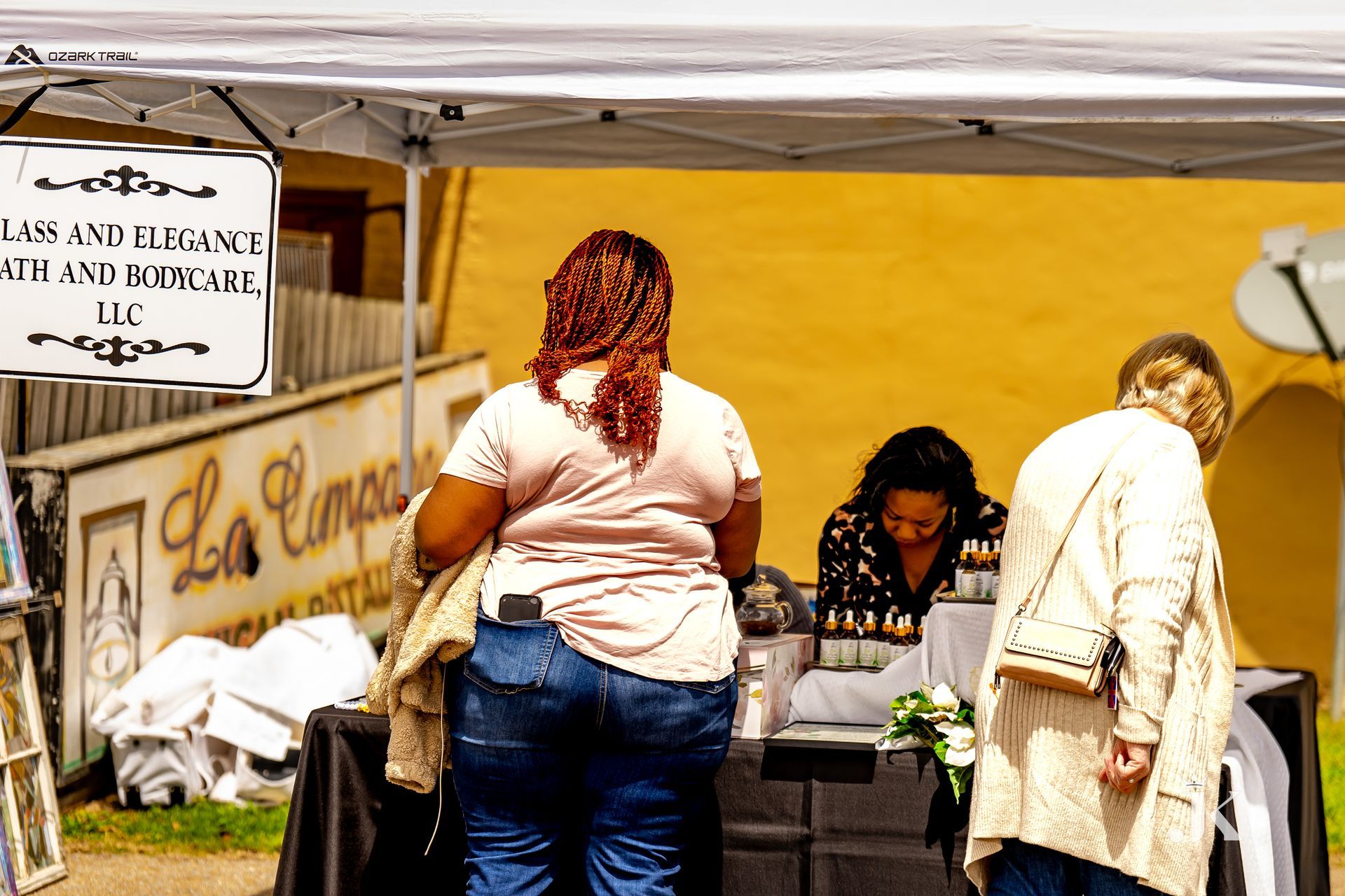 A woman standing under a tent with a sign that says law and elegance