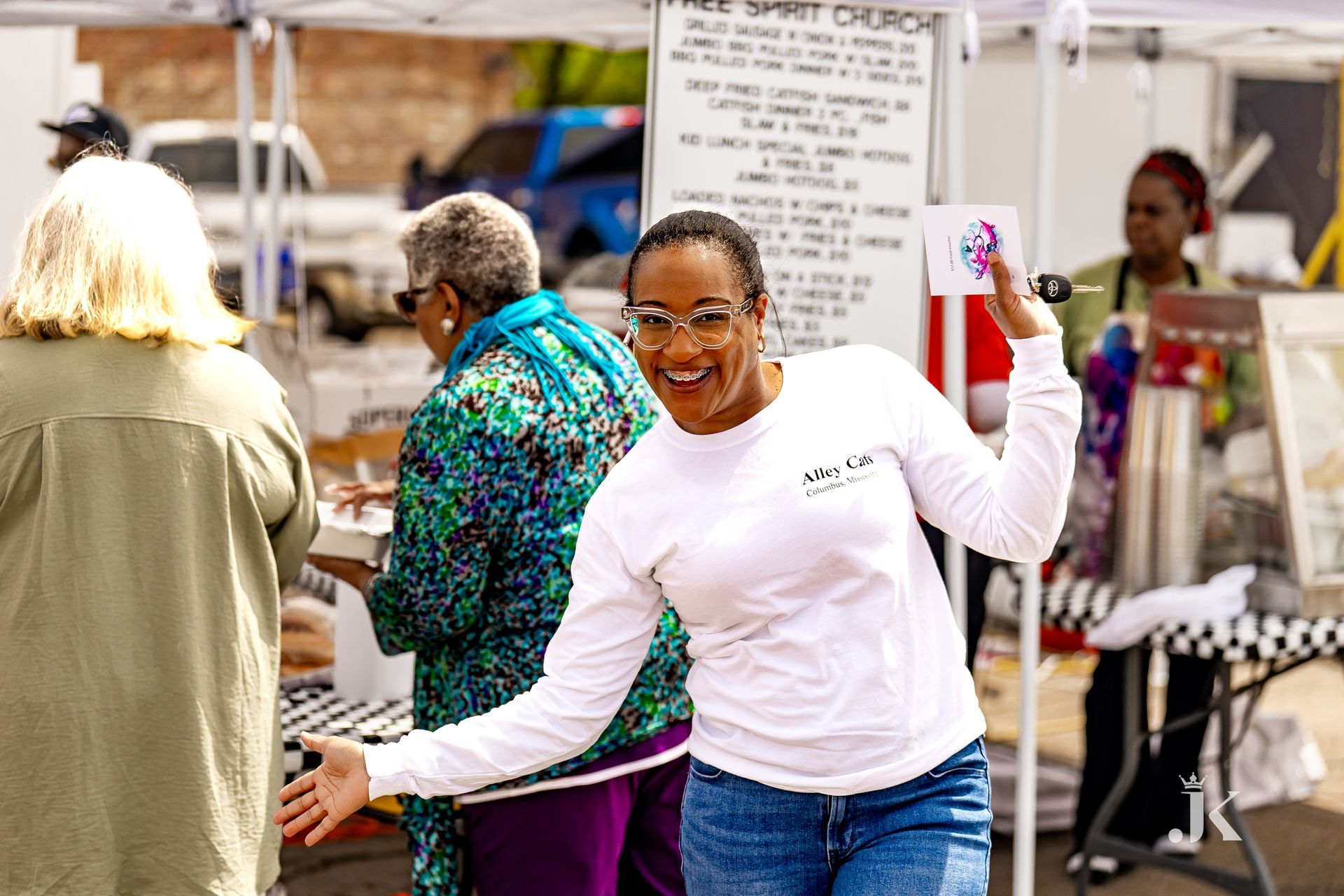 A woman is standing in front of a tent holding a hula hoop.