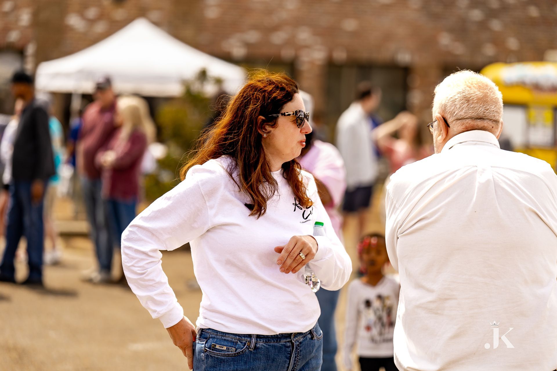 A woman in a white shirt is standing next to a man in a white shirt.