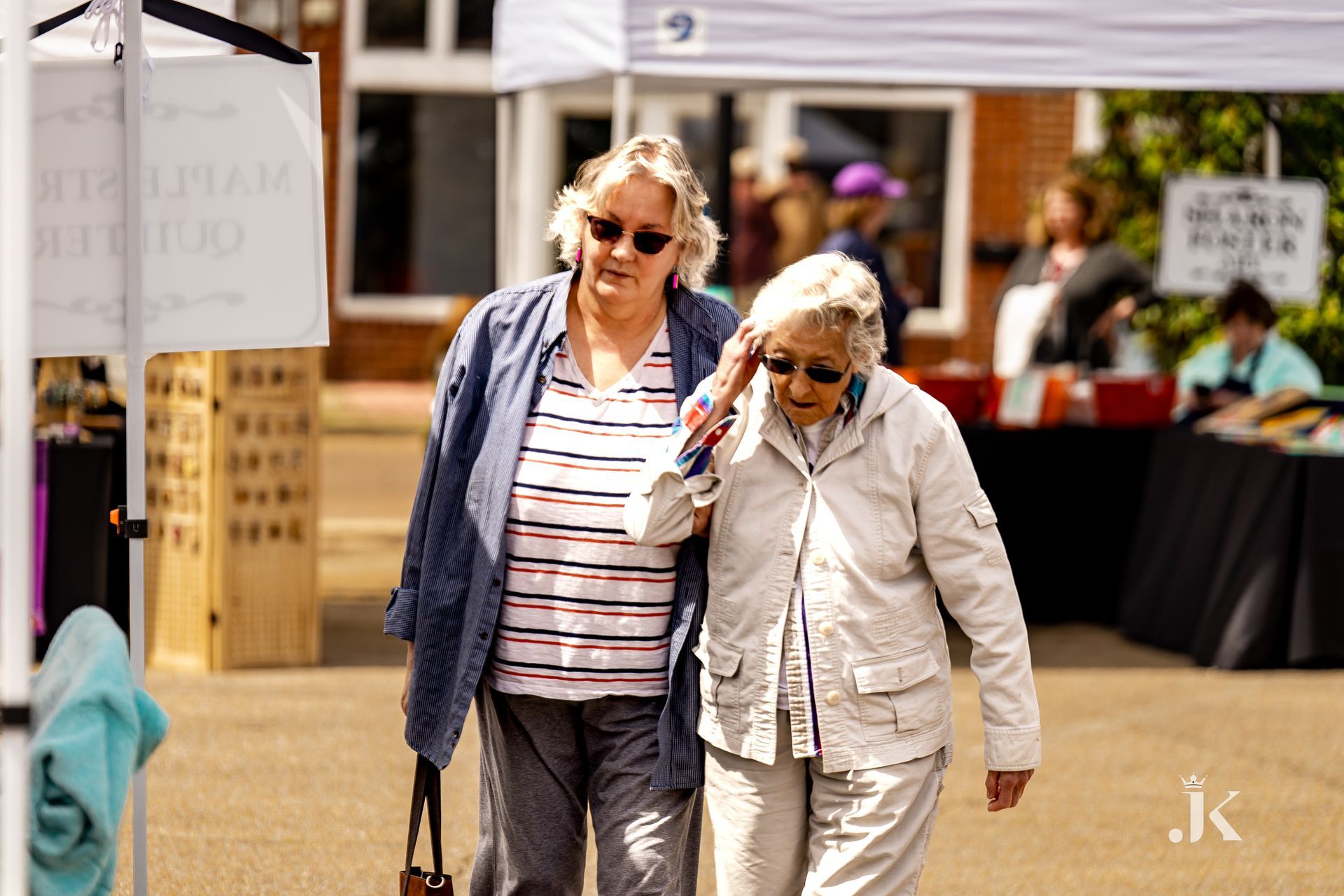 Two older women are walking down a street together.