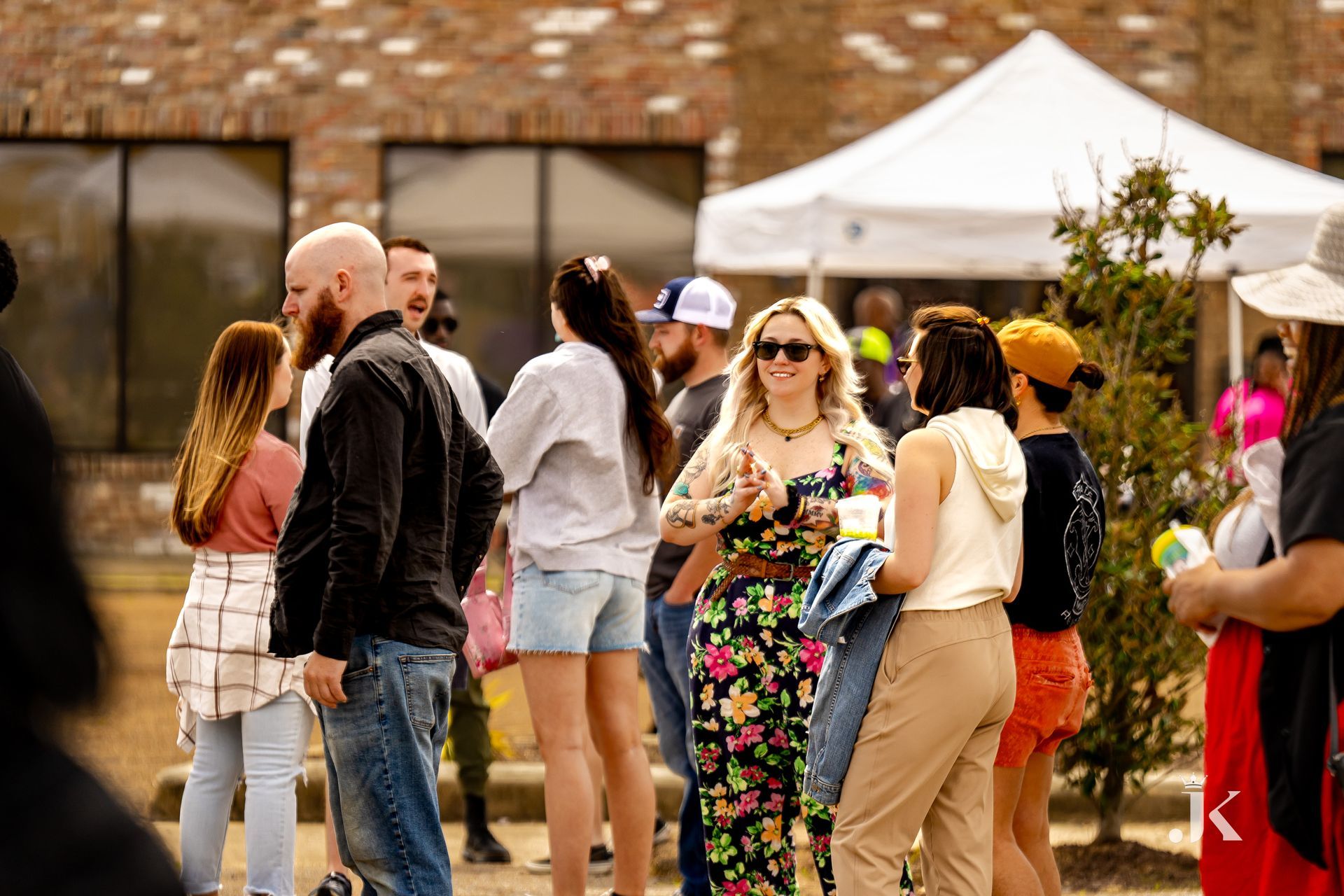A group of people are standing outside of a building talking to each other.