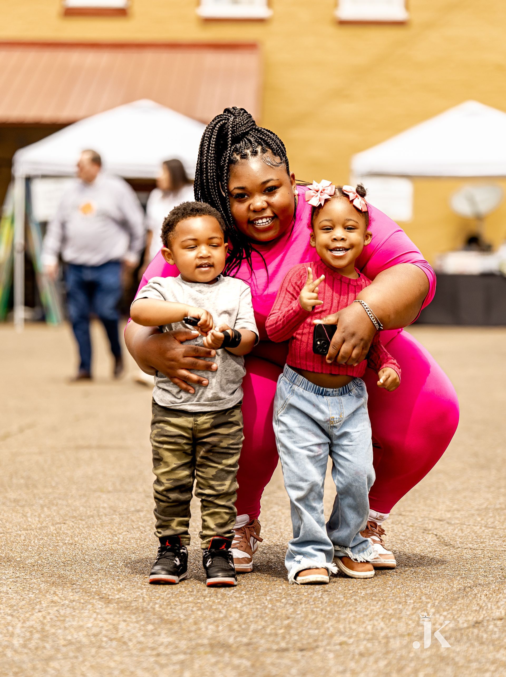 A woman is posing for a picture with two children.