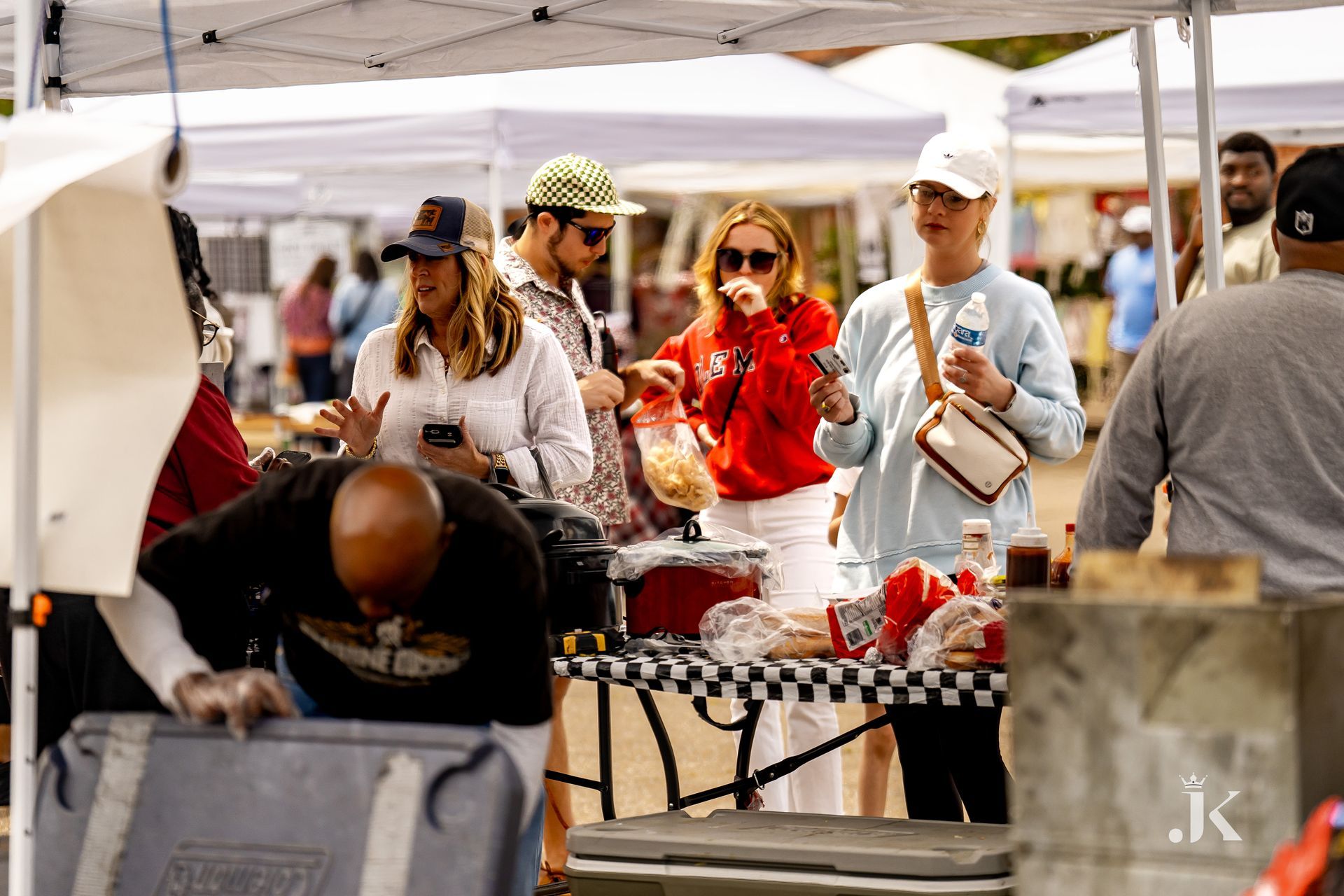 A group of people are standing around a table at a market.