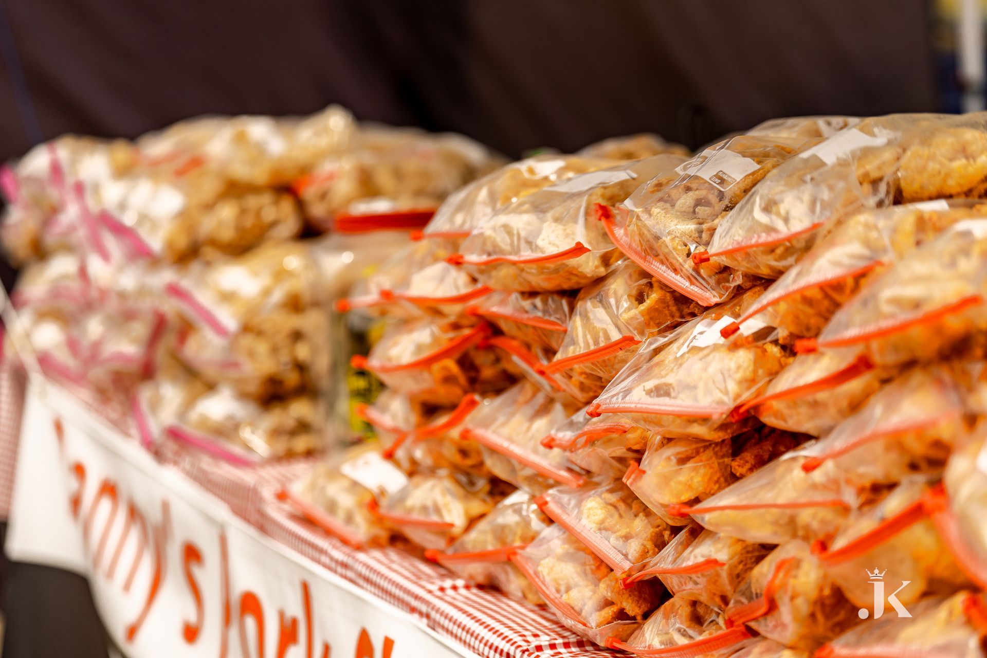 A bunch of bags of food are stacked on top of each other on a table.