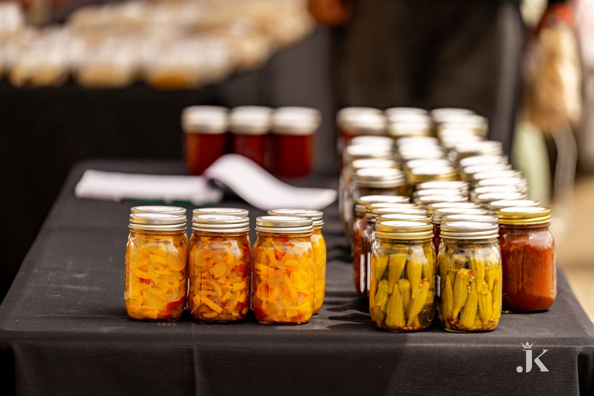 There are many jars of pickles on the table.