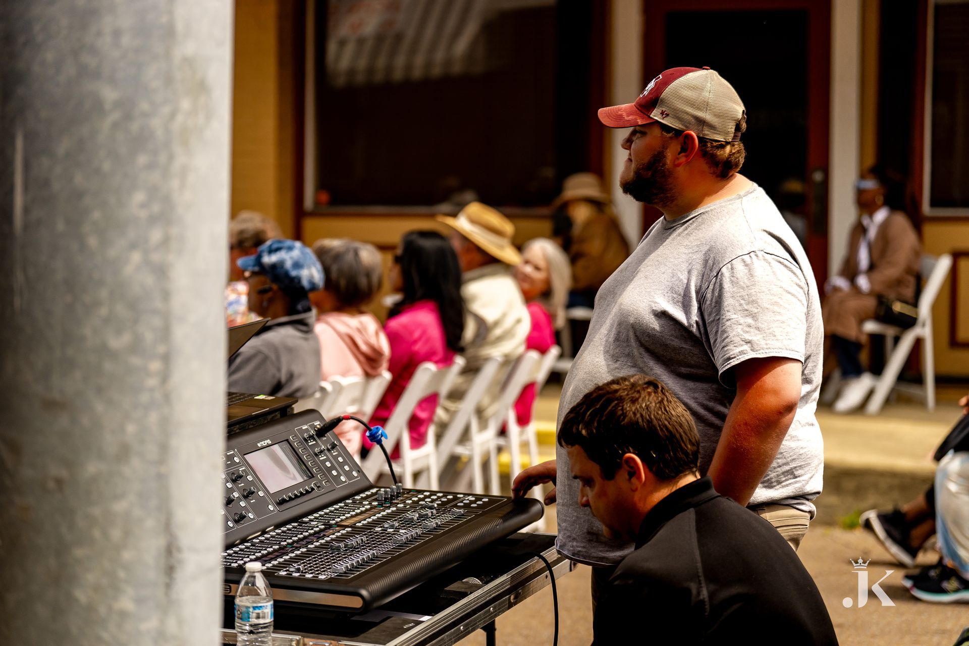 A man is standing next to a keyboard in front of a crowd of people.