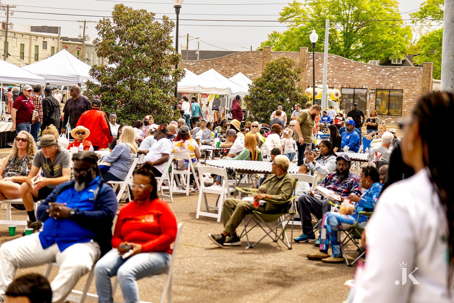 A large group of people are sitting in chairs at a festival.