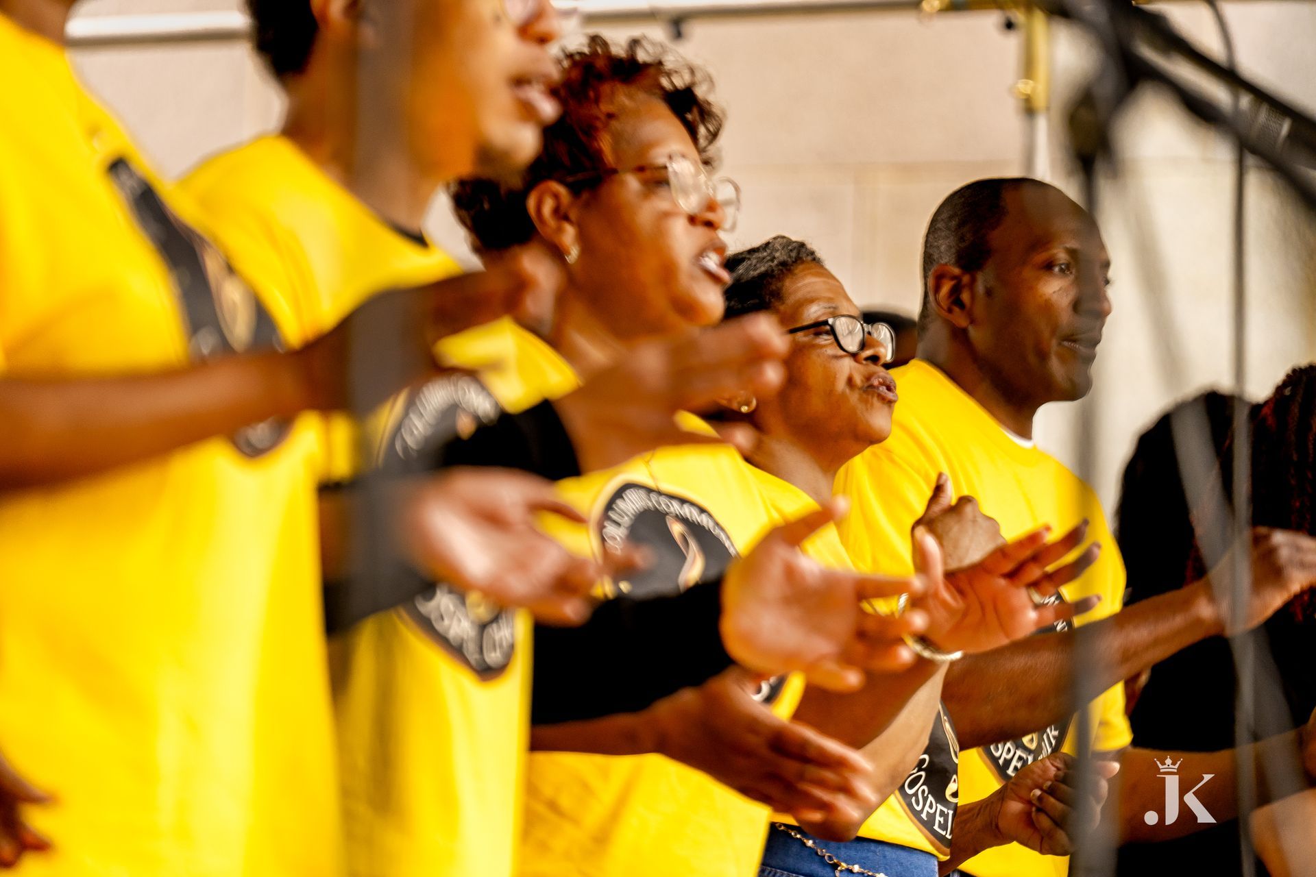 A group of people in yellow shirts are singing together