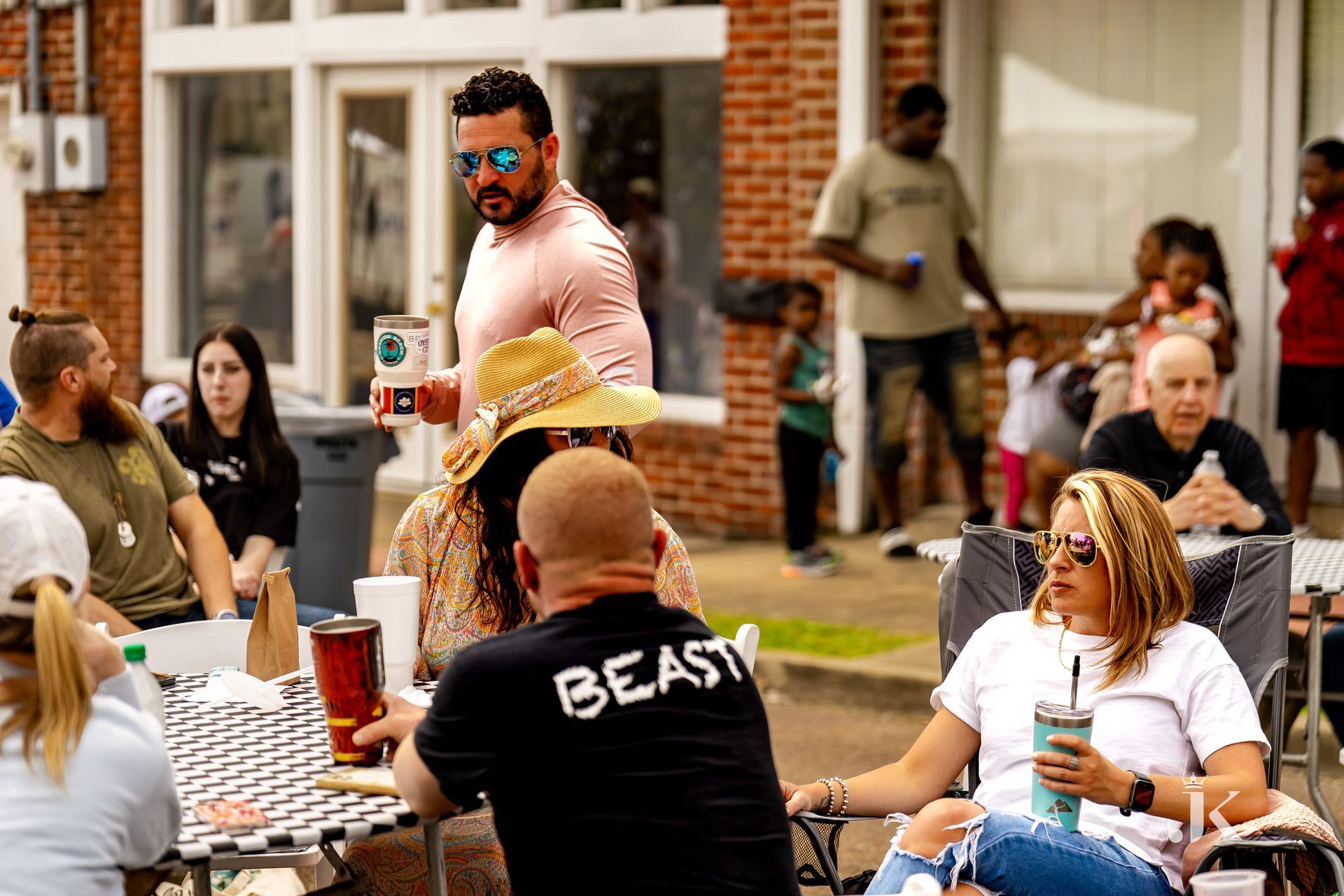A group of people are sitting at a table outside of a building.