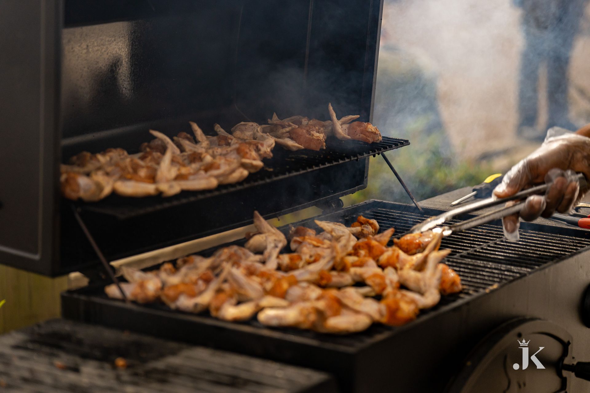 A person is cooking shrimp on a grill.