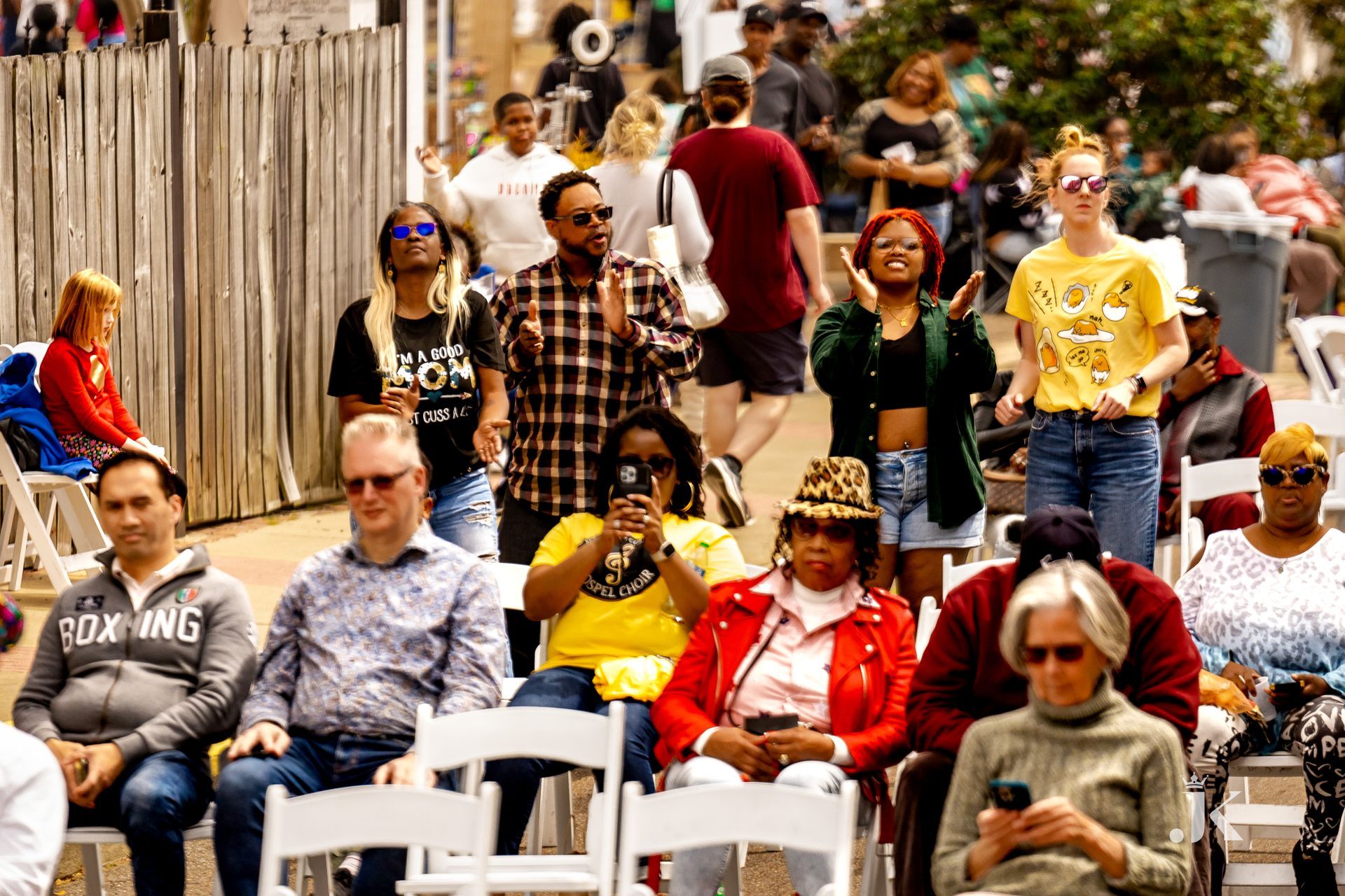 A crowd of people are sitting in chairs at a festival.