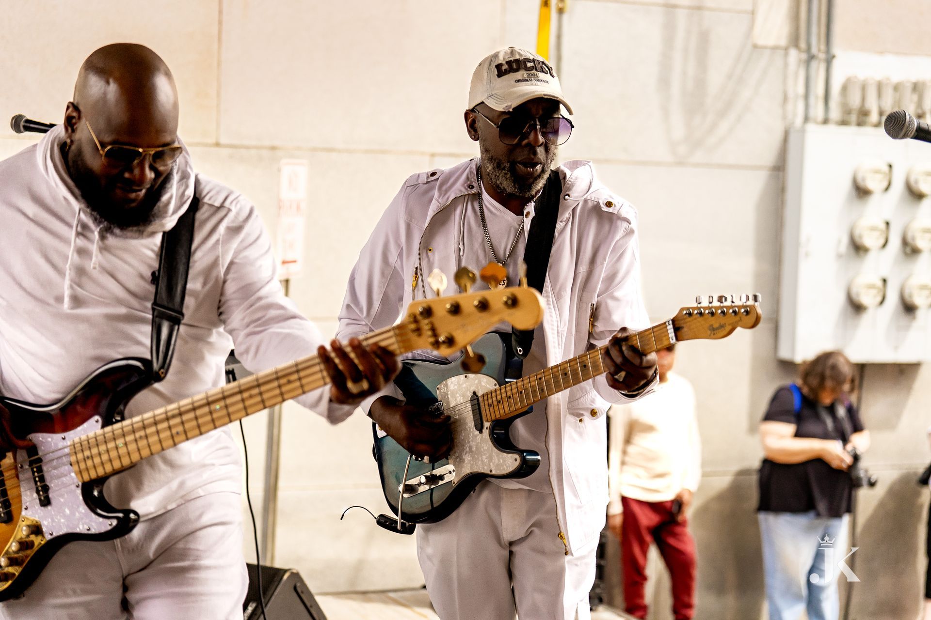 Two men are playing guitars in front of a crowd.