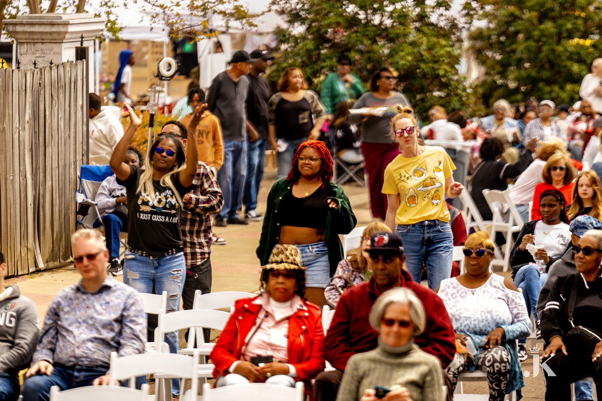A crowd of people are sitting in chairs at a festival.