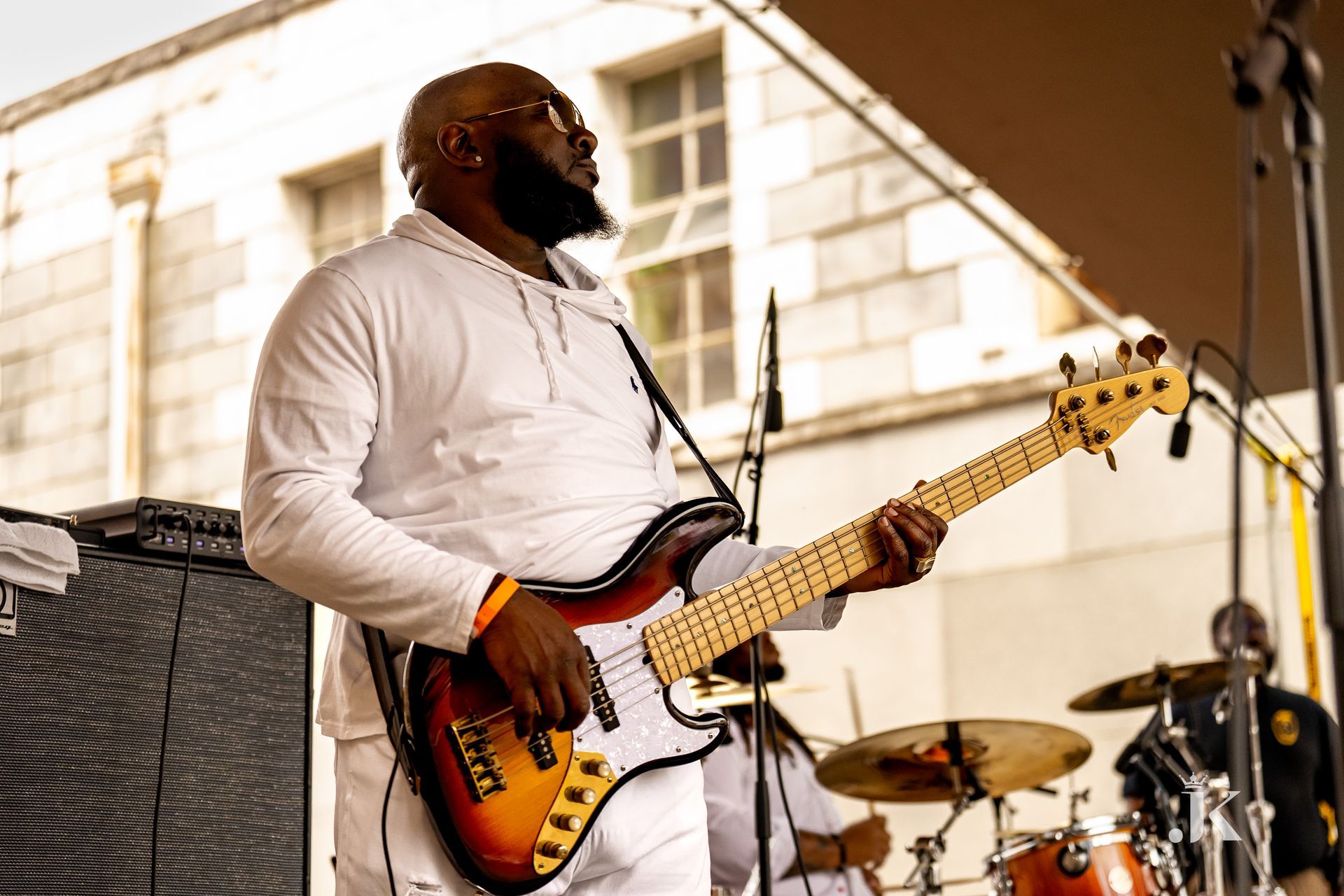 A man in a white shirt is playing a guitar on a stage.